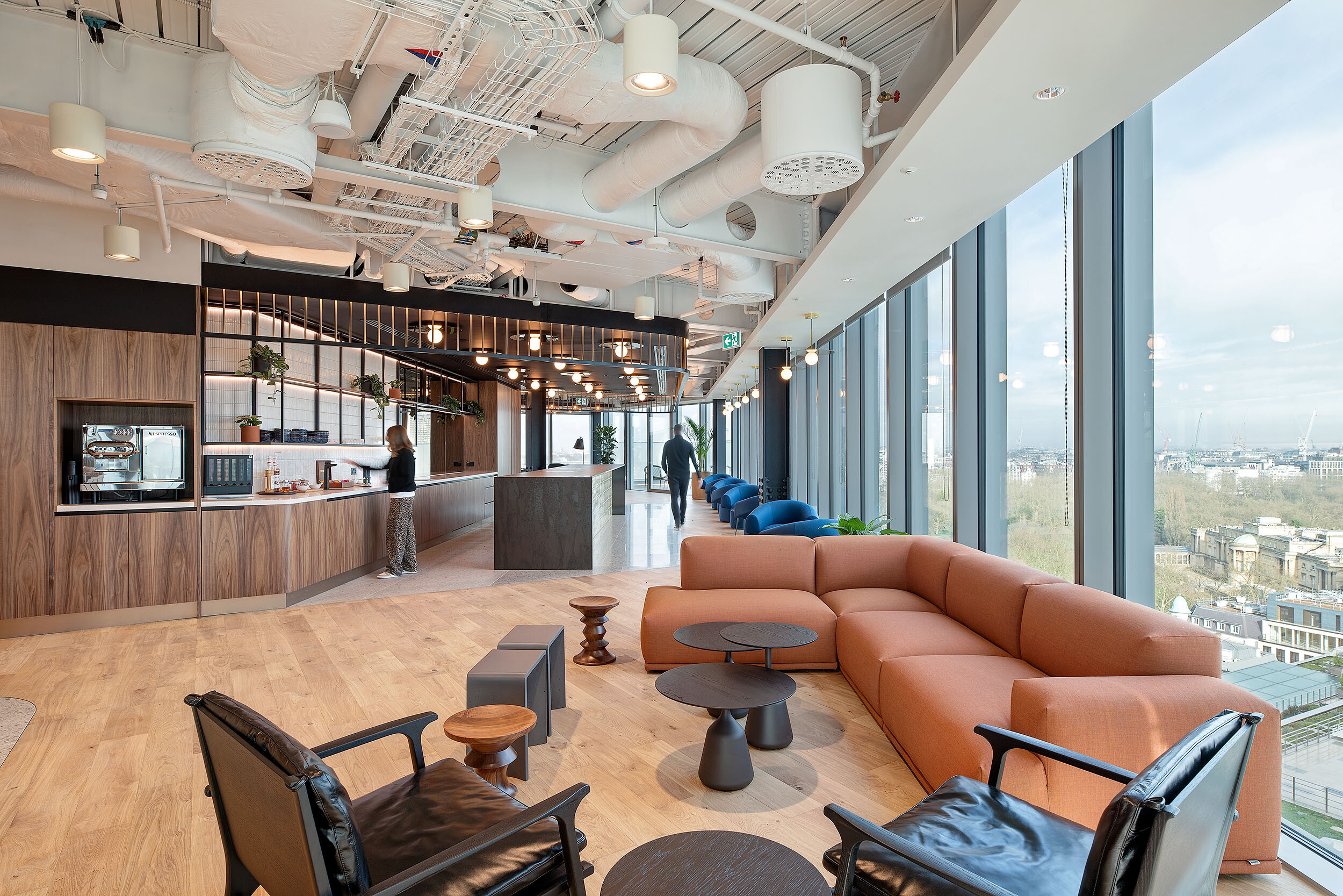 Social lounge and kitchen space at International Technology and Data Firm with terracotta modular seating and views across London’s skyline.