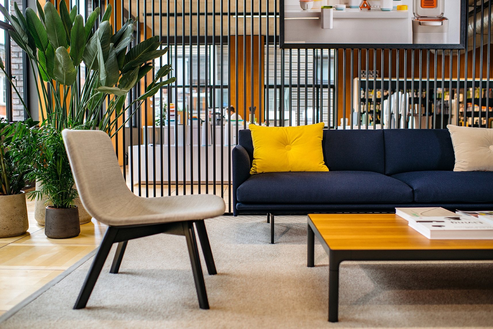 Close-up of the Joseph Joseph reception seating area, with modern lounge furniture, potted plants, and a timber slatted backdrop.