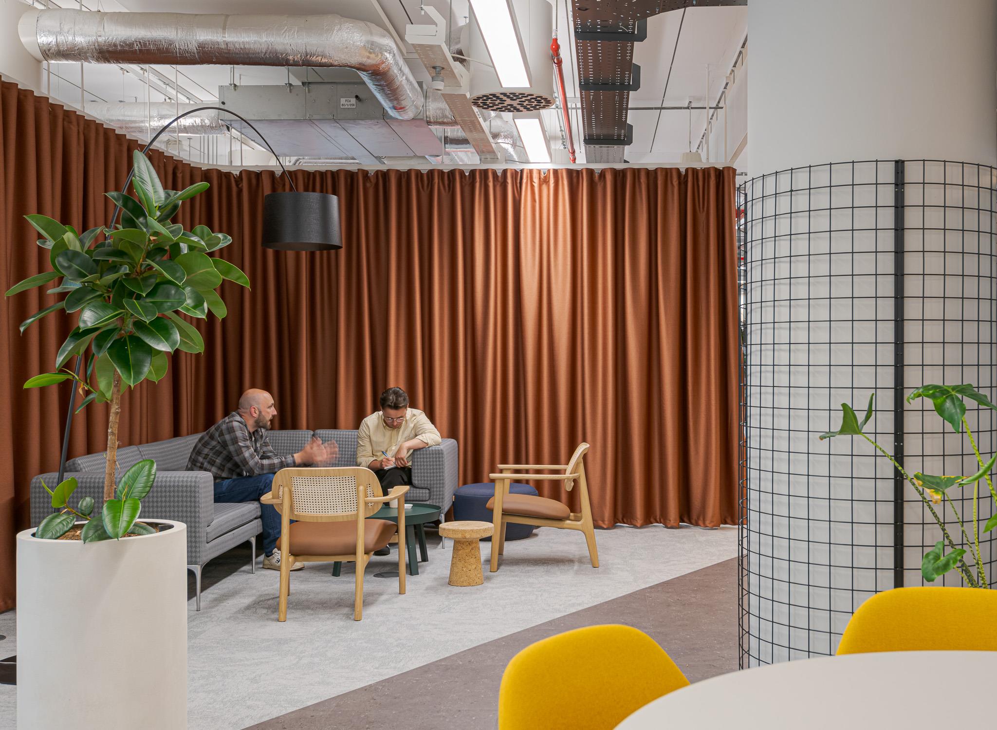 Meeting space at Landsec’s HQ, featuring soft lounge seating, warm-toned curtains and a mix of timber and upholstered furniture for a relaxed setting.