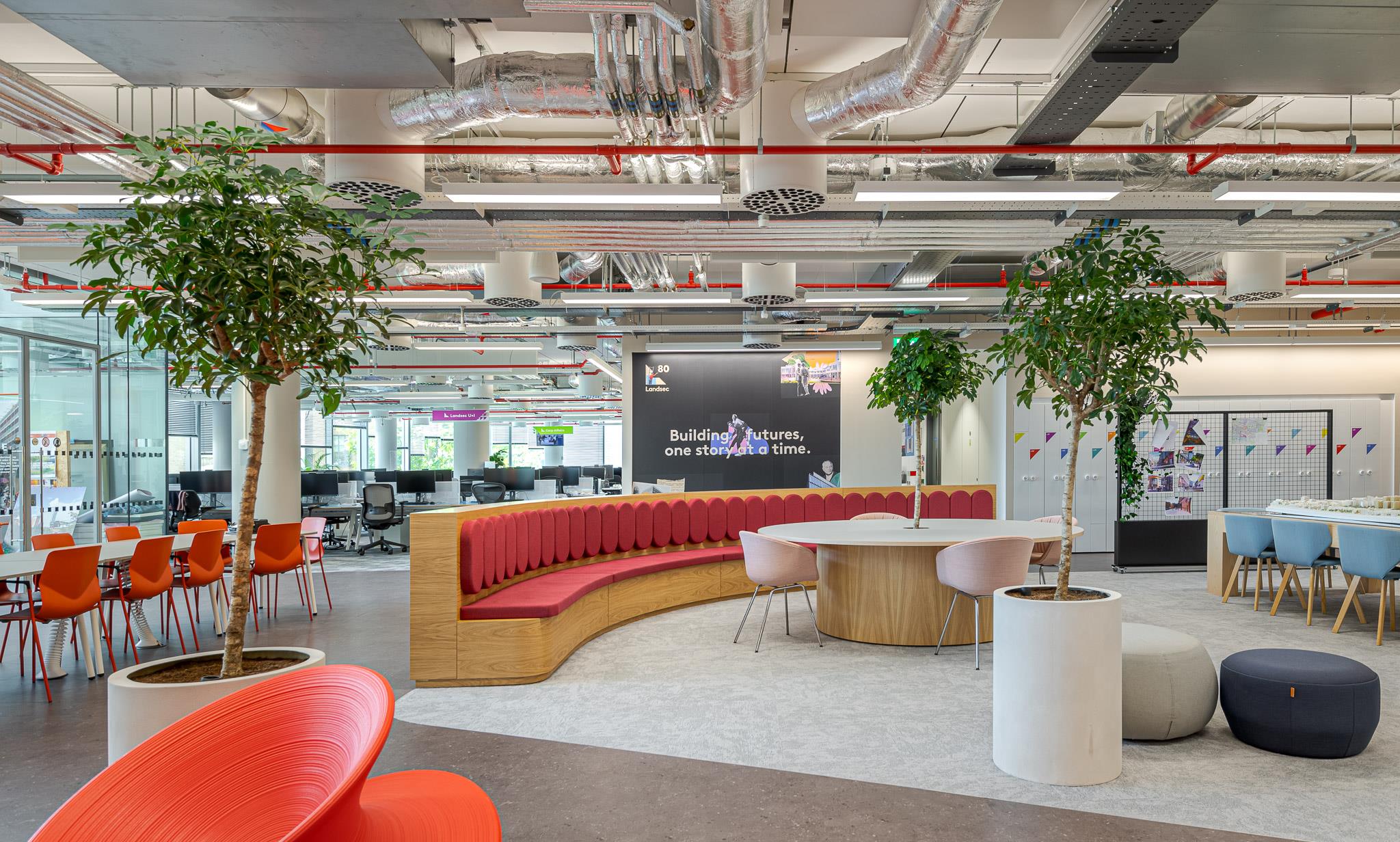 Collaboration zone at Landsec’s HQ, with bespoke curved seating, round tables and colourful furniture that reflects a dynamic, people-focused workspace.