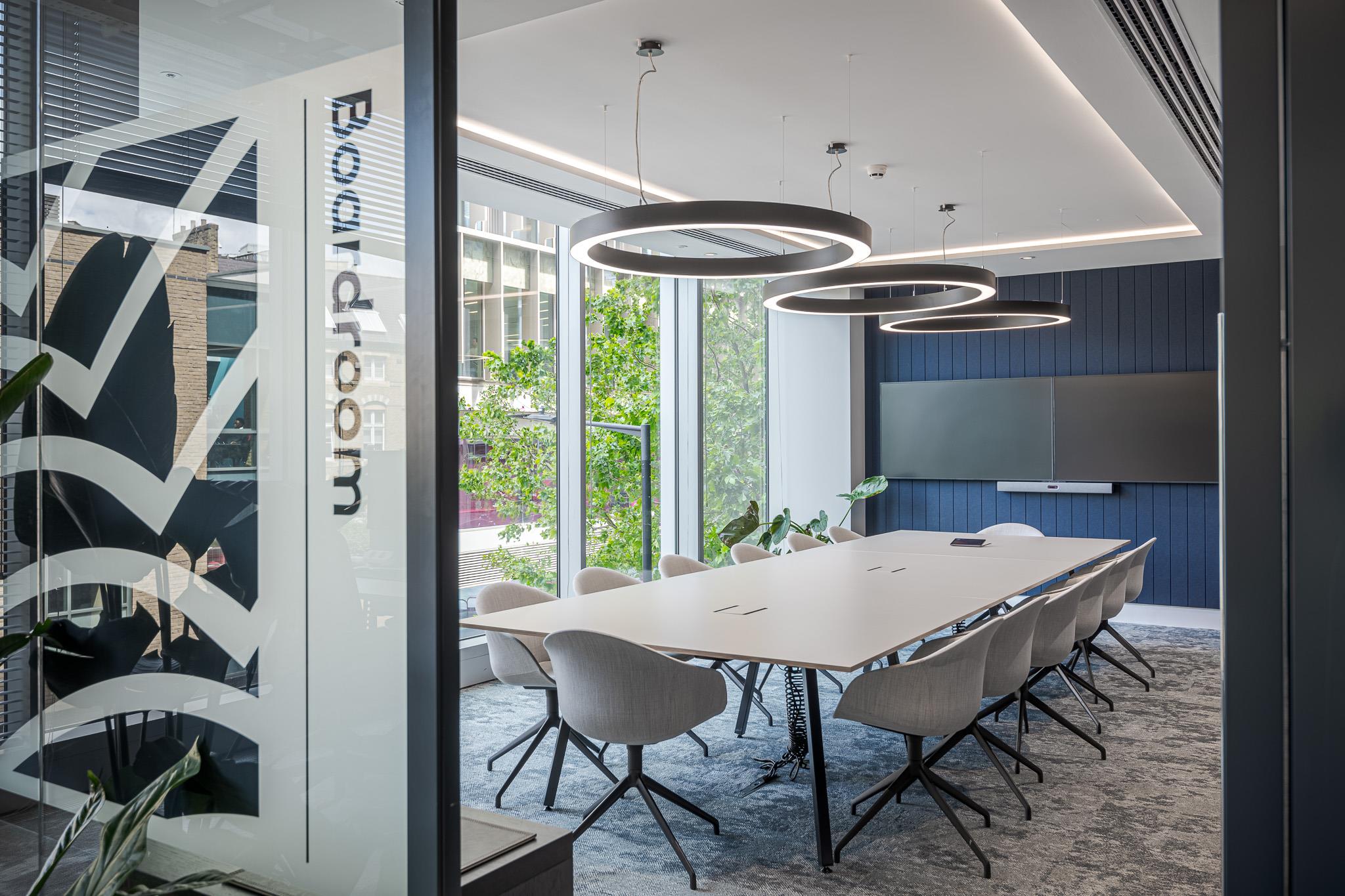 Contemporary boardroom at Landsec’s HQ, with ergonomic chairs, a large meeting table, circular pendant lighting and floor-to-ceiling windows for natural light.