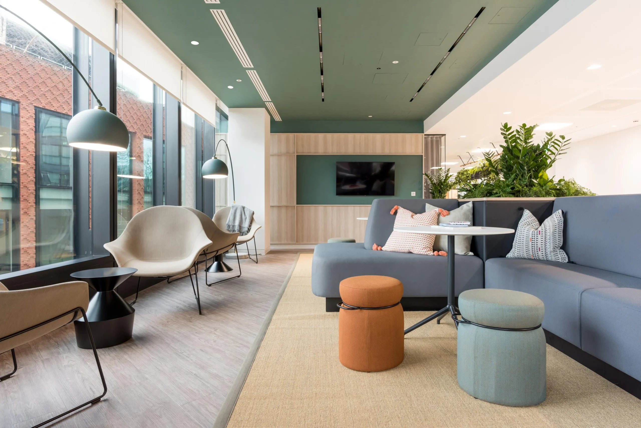 Breakout lounge for London & Oriental with curved seating, soft accent stools, and arched floor lamps, styled with layered textures and integrated planters.