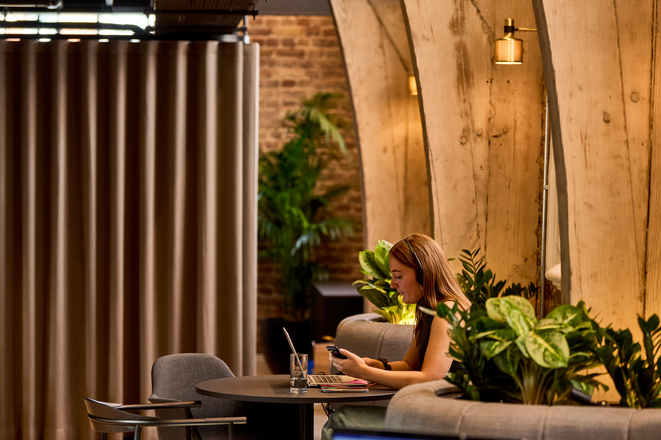 Breakout area furniture supplied for Lotus, creating a relaxed work setting beneath curved timber beams and surrounded by planting.