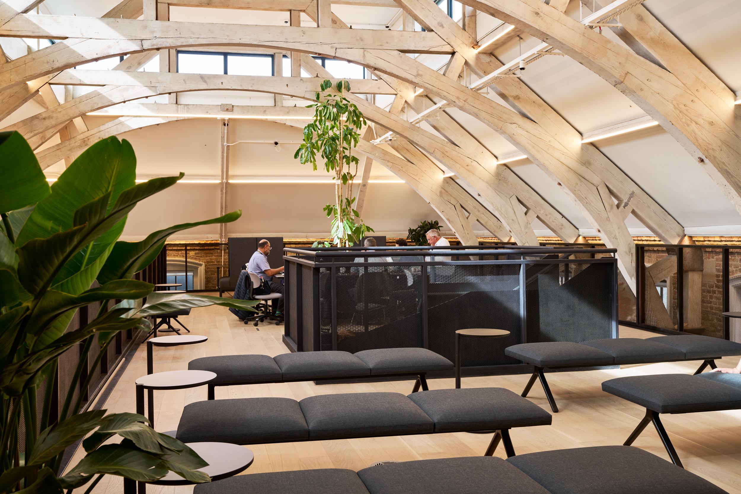 Furniture supplied for Lotus’ mezzanine workspace, combining modular bench seating and task chairs beneath exposed timber arches and large skylights.