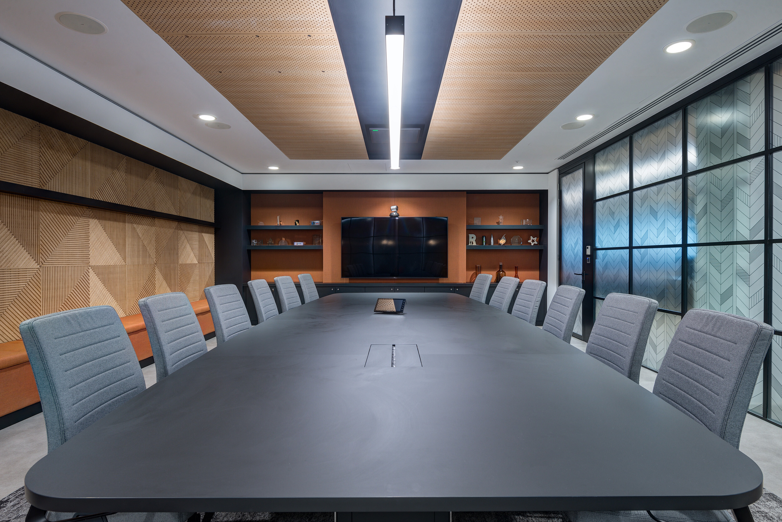 Boardroom at MITIE's Shard office featuring a matte black table, upholstered grey chairs, and bespoke joinery installed with Platfform furniture.