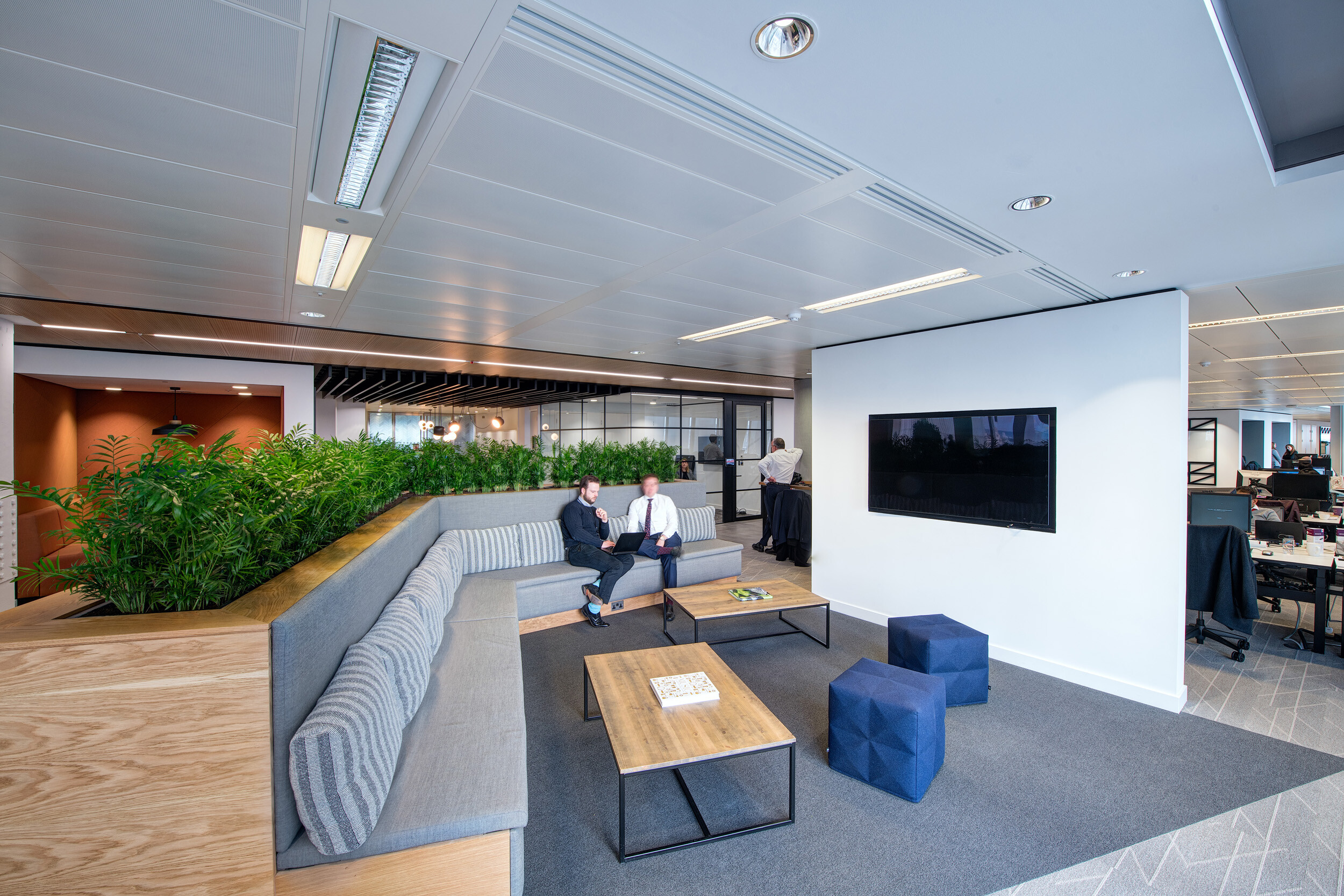 Informal collaboration area at MITIE's Shard office, complete with bespoke tiered seating, coffee tables, and pouffes supplied by Platfform.
