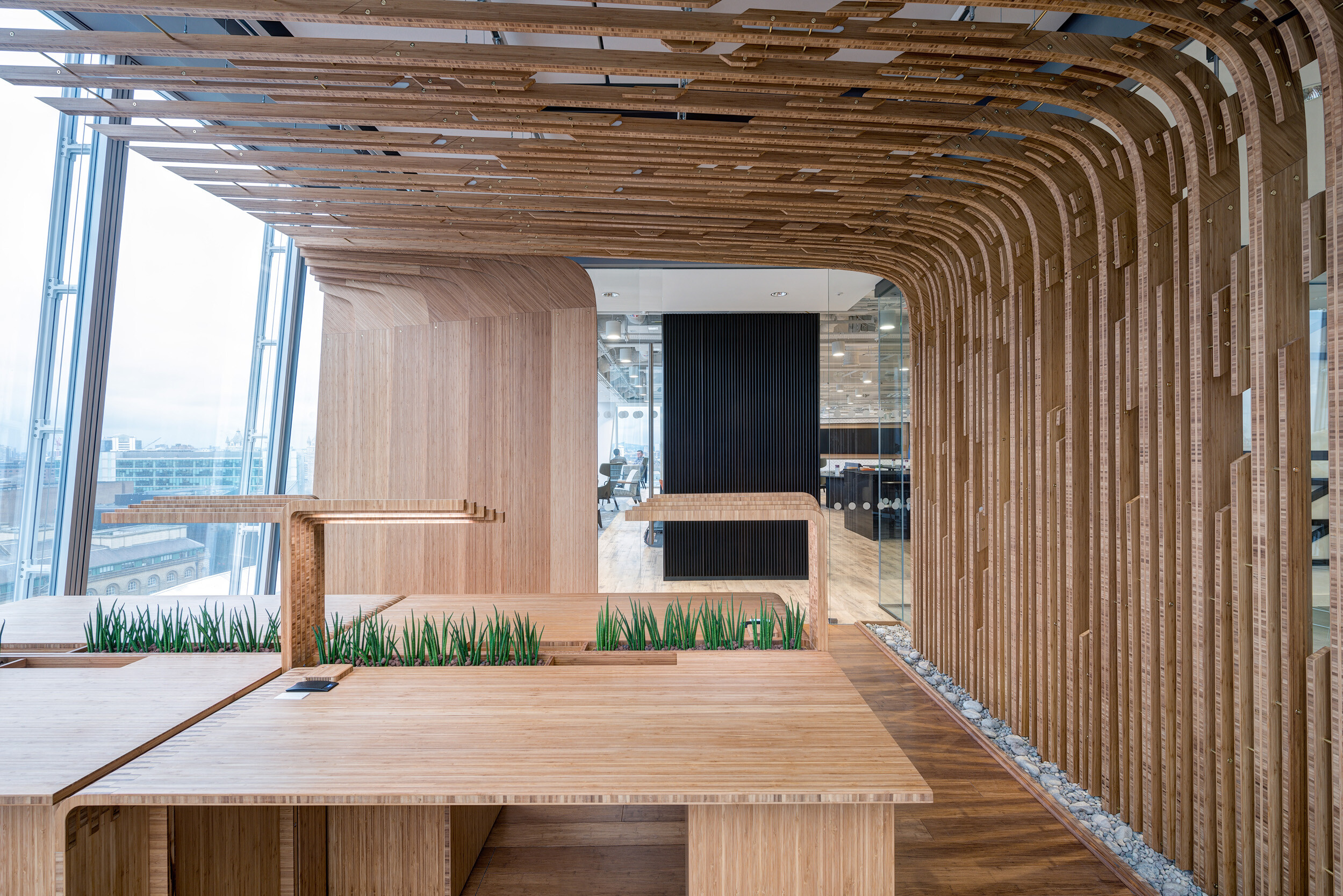 Bespoke timber workspace with sculptural detailing and integrated planting at MITIE's Shard office, furnished in collaboration with Platfform.