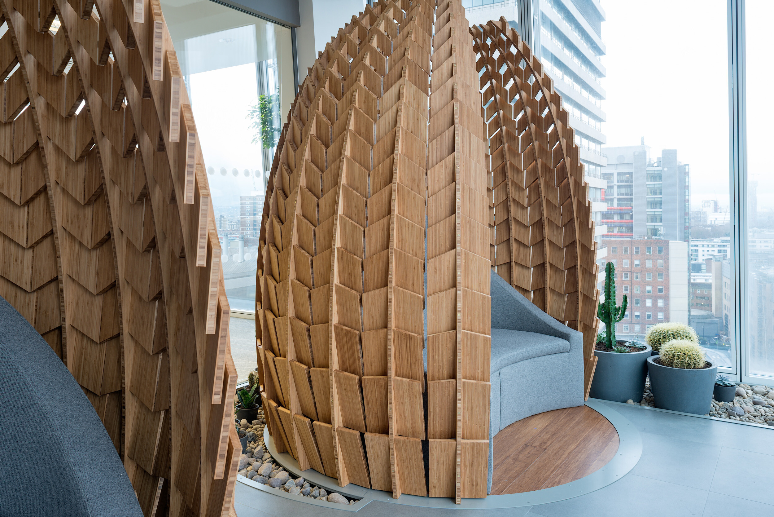 Close-up of timber pod seating at MITIE's Shard office, designed for focused work and fitted with curved upholstery by Platfform.