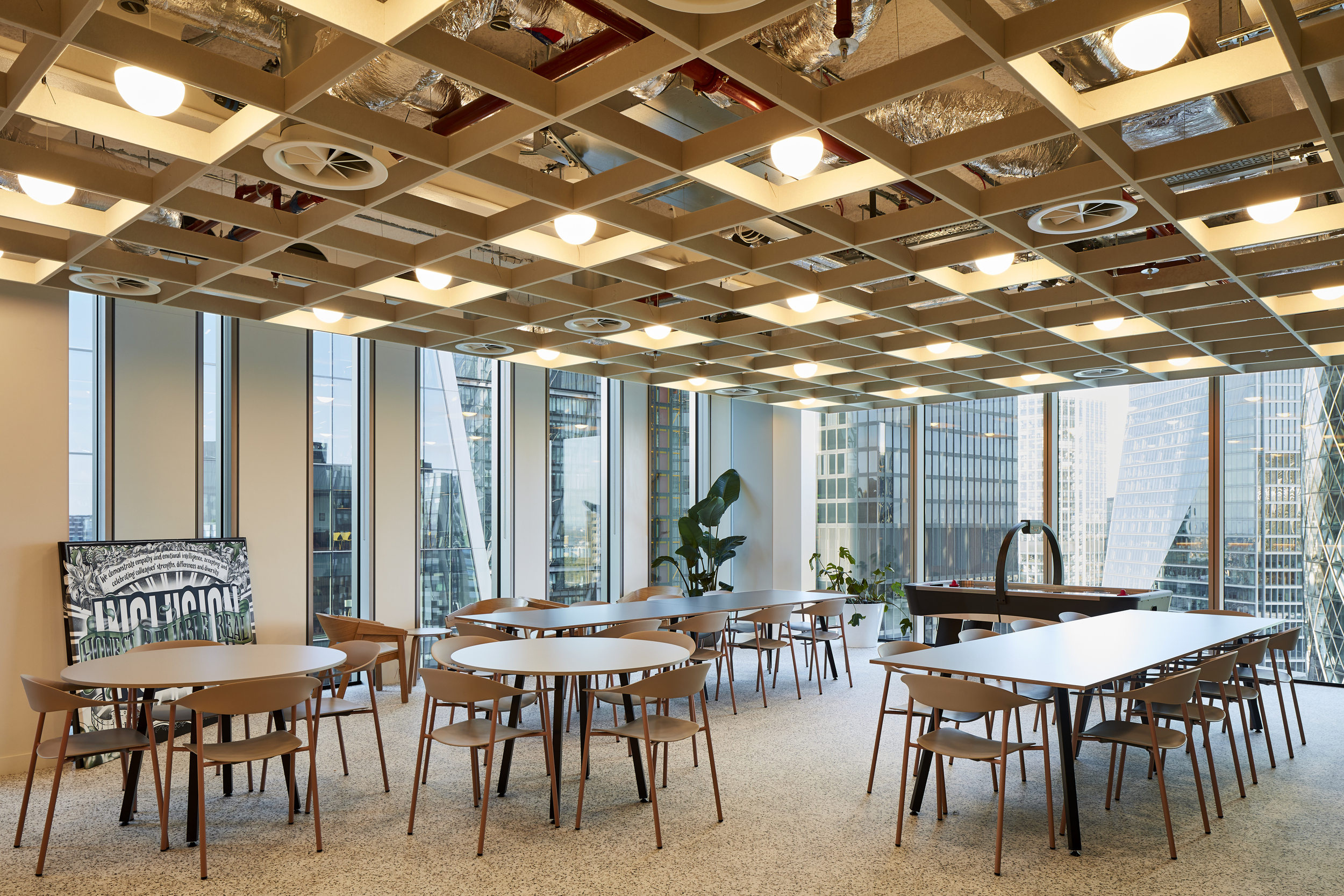 Breakout area at McGill & Partners featuring round and rectangular tables with warm timber chairs, installed by Platfform.