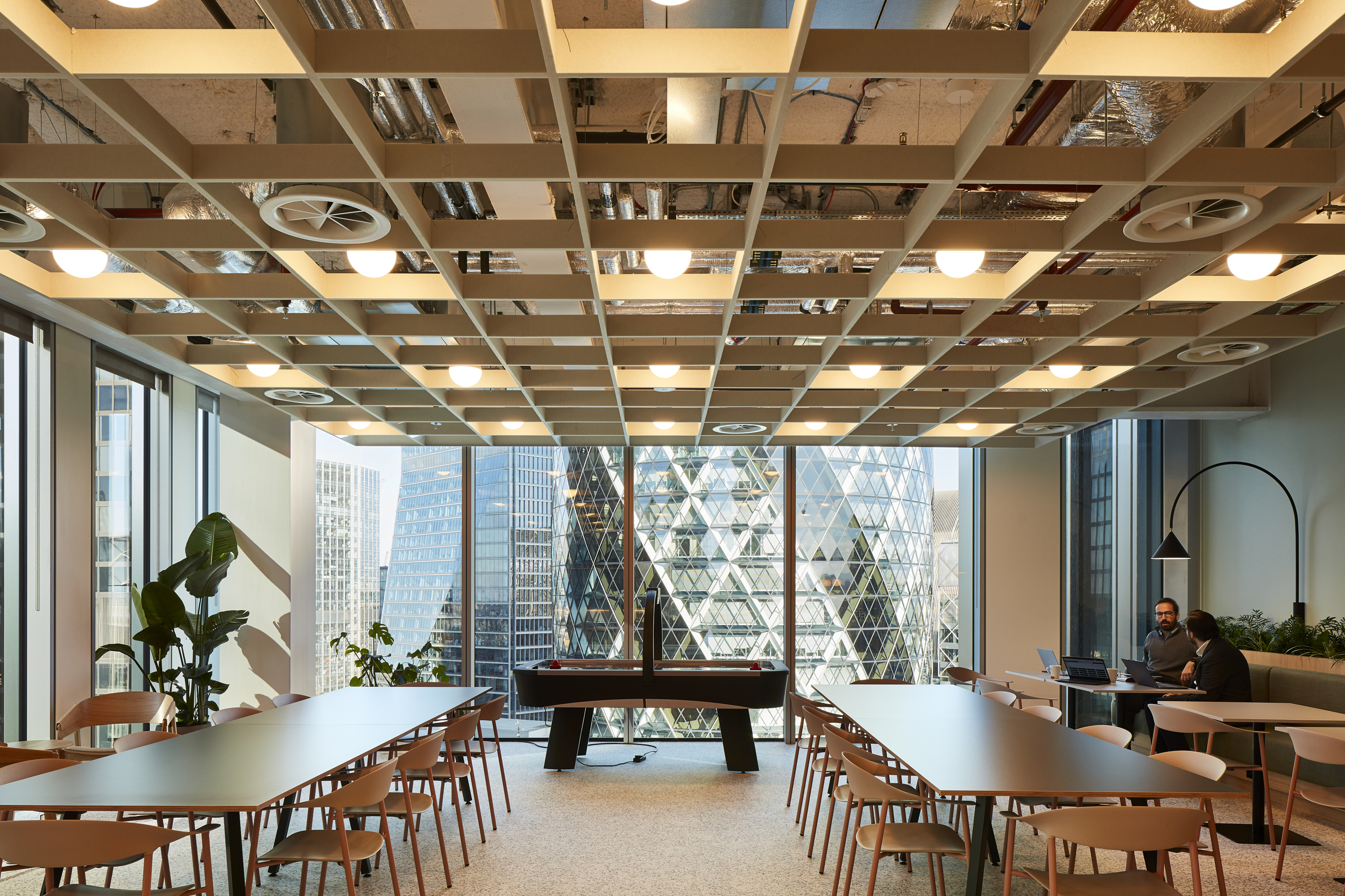 Social space at McGill & Partners with Platfform-supplied tables, timber chairs and built-in banquette seating, overlooking the Gherkin.