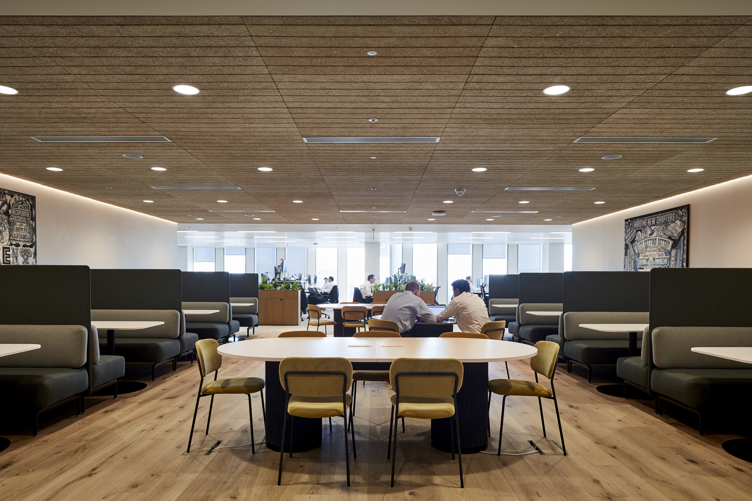 Workspace at McGill & Partners with Platfform-supplied booth seating and a central meeting table with yellow upholstered chairs.