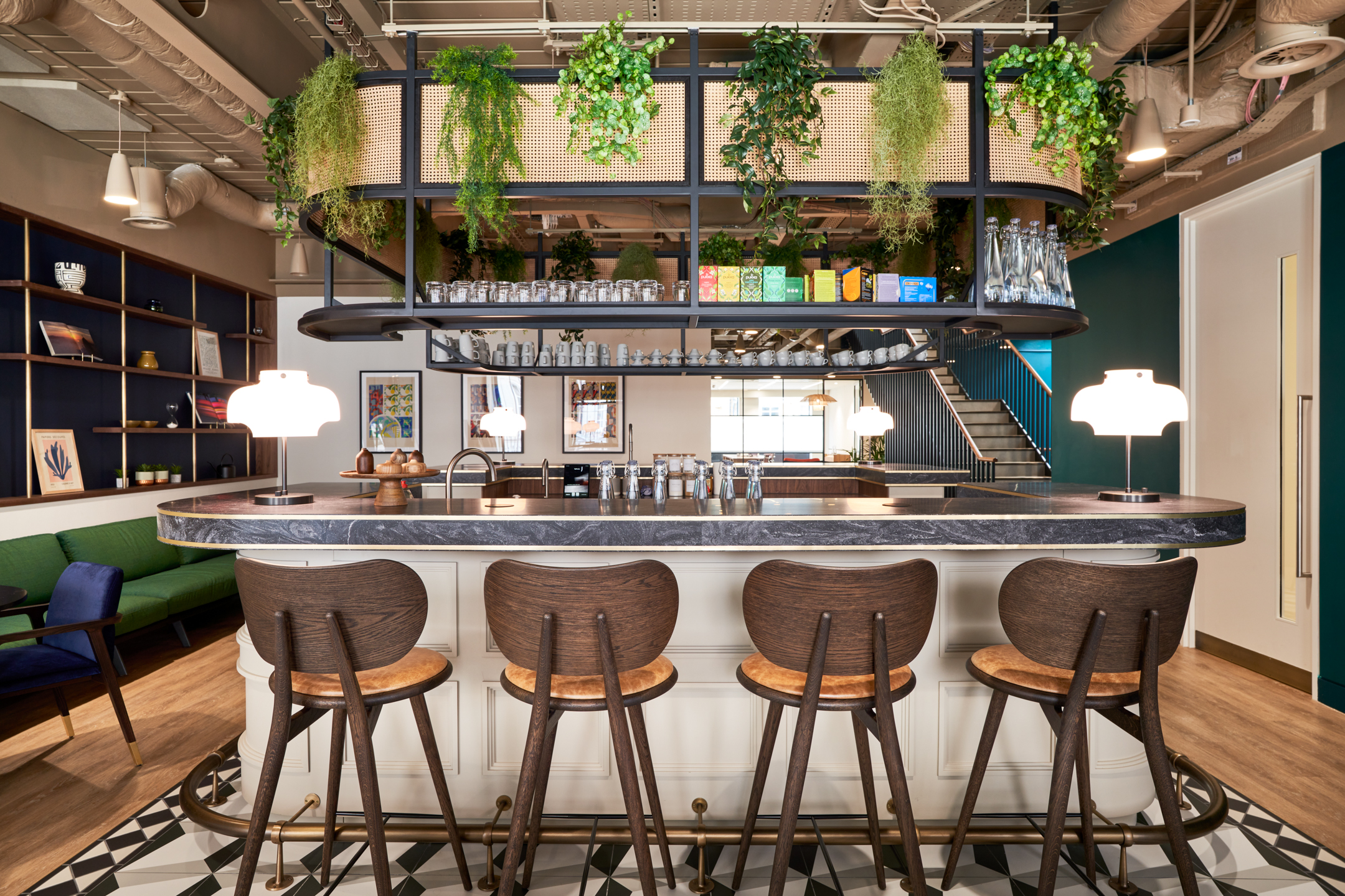 A stylish breakout bar area with rich wood furniture and hanging greenery, part of the office fit out for Private Equity Fund.