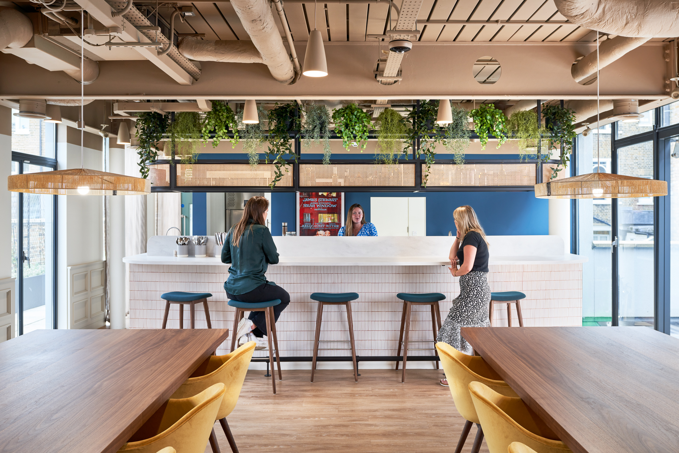 Bright and welcoming teapoint breakout space at Private Equity Fund’s office, complete with timber stools, greenery, and soft pendant lighting.