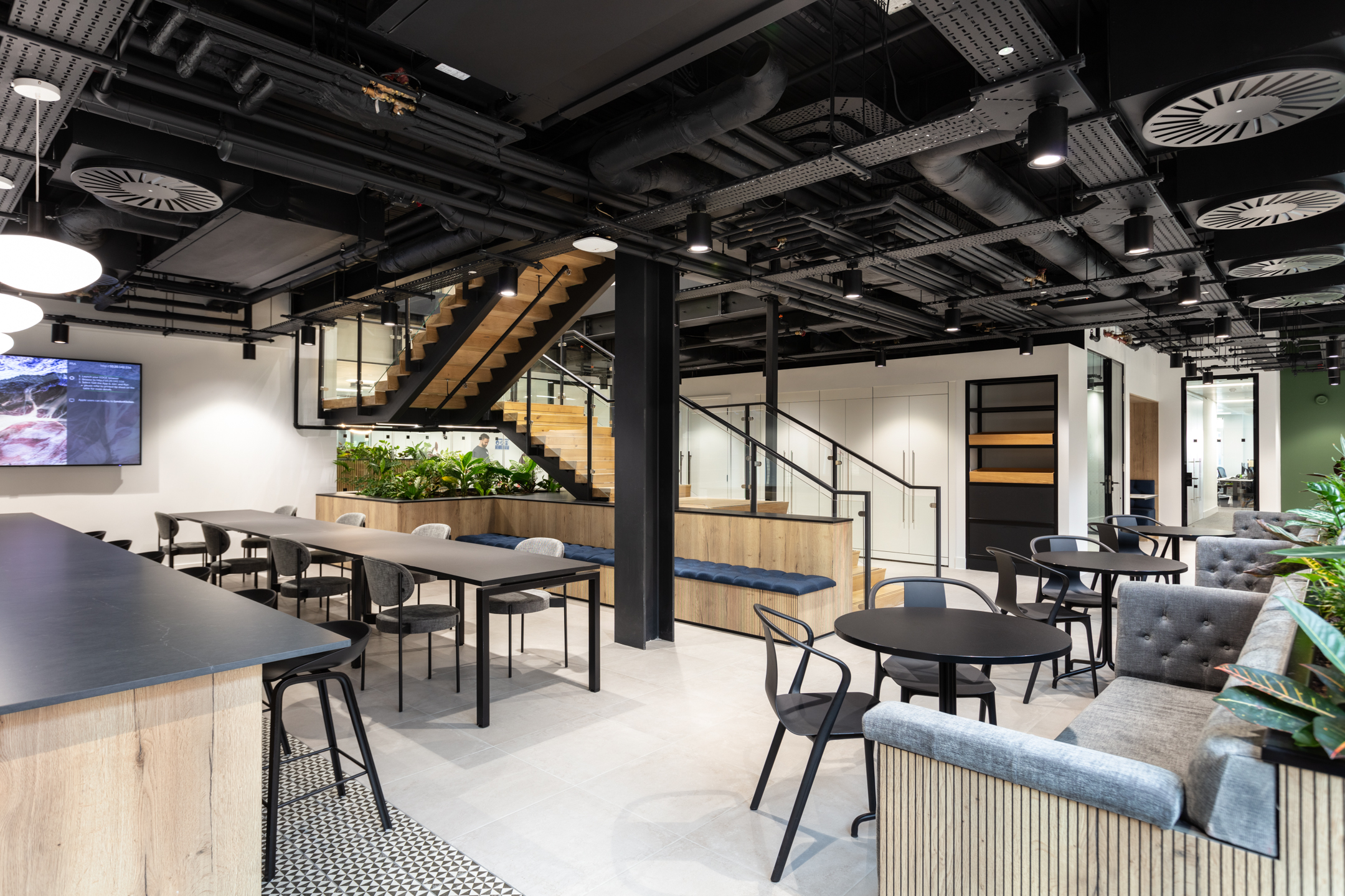 Relaxed breakout area for Russell Reynolds Associates with a mix of soft seating, round café tables and tailored furniture from Platfform.