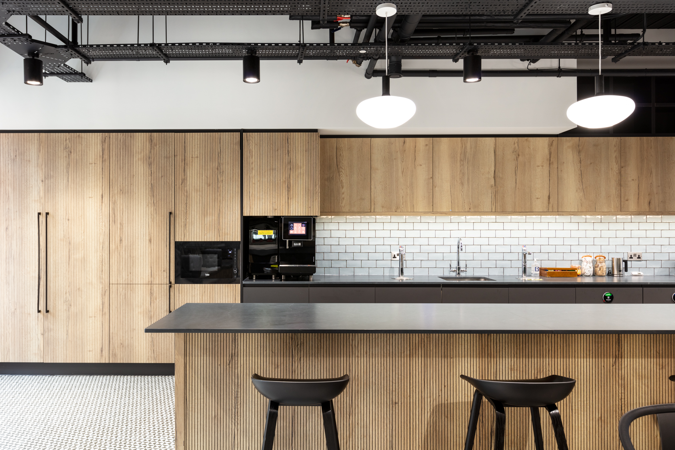Teapoint for Russell Reynolds Associates with light wood cabinetry, black accents and furniture by Platfform designed for everyday use and comfort.
