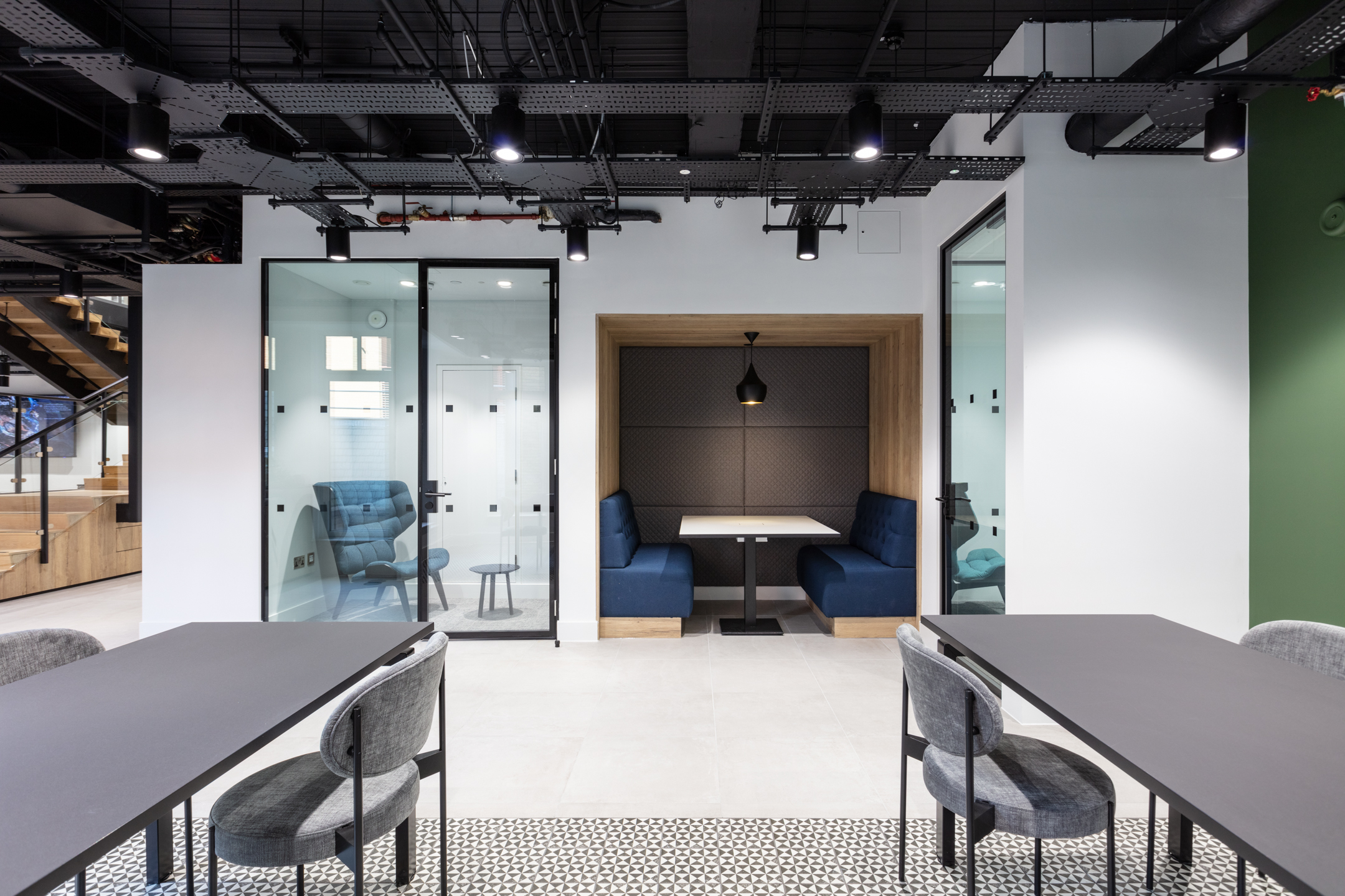 Russell Reynolds Associates workspace with a private booth, soft blue upholstery and acoustic seating by Platfform for quiet focus and informal chats.