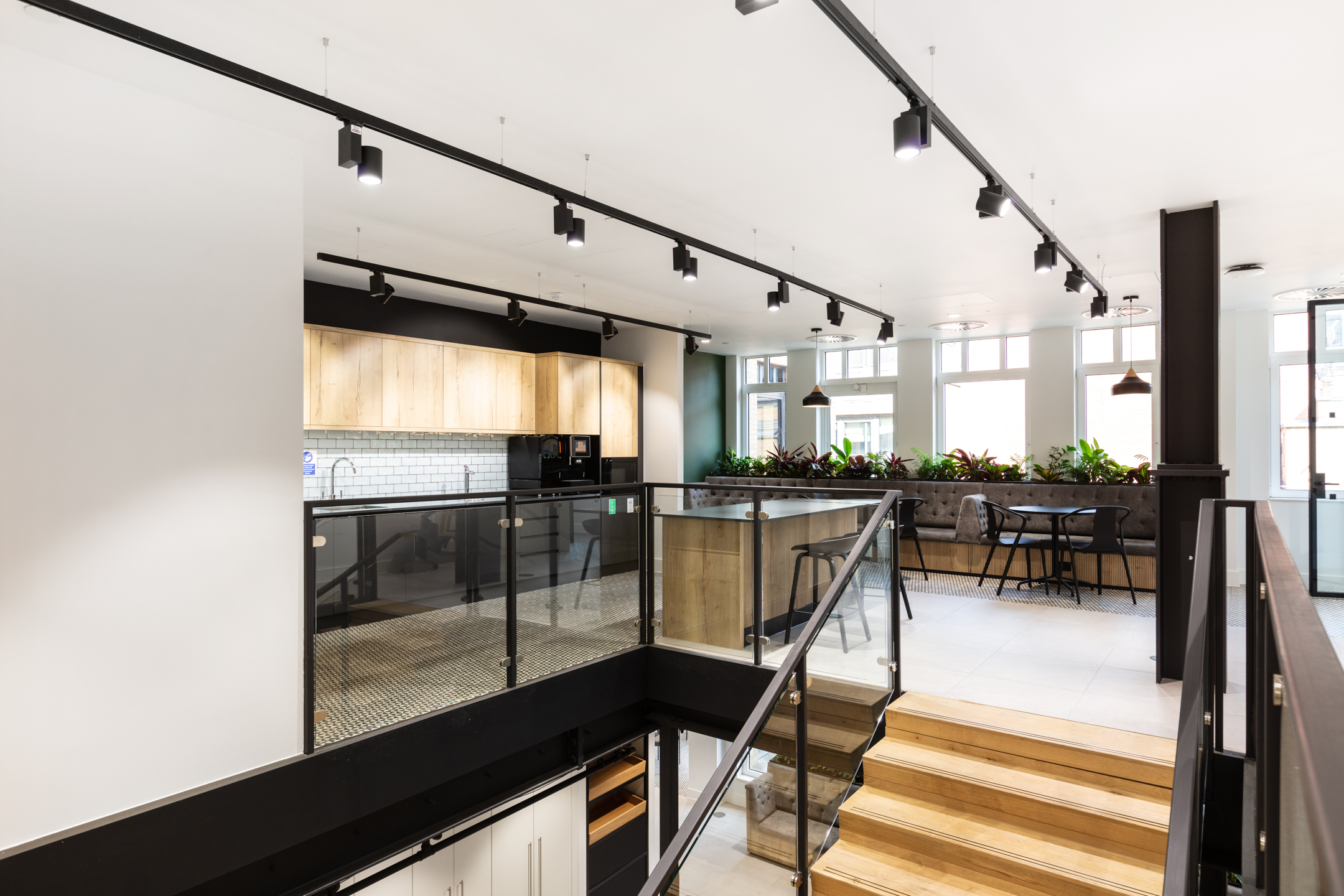 Upper level kitchen and social space for Russell Reynolds Associates, with bar stools, soft seating and furniture by Platfform placed along natural light.