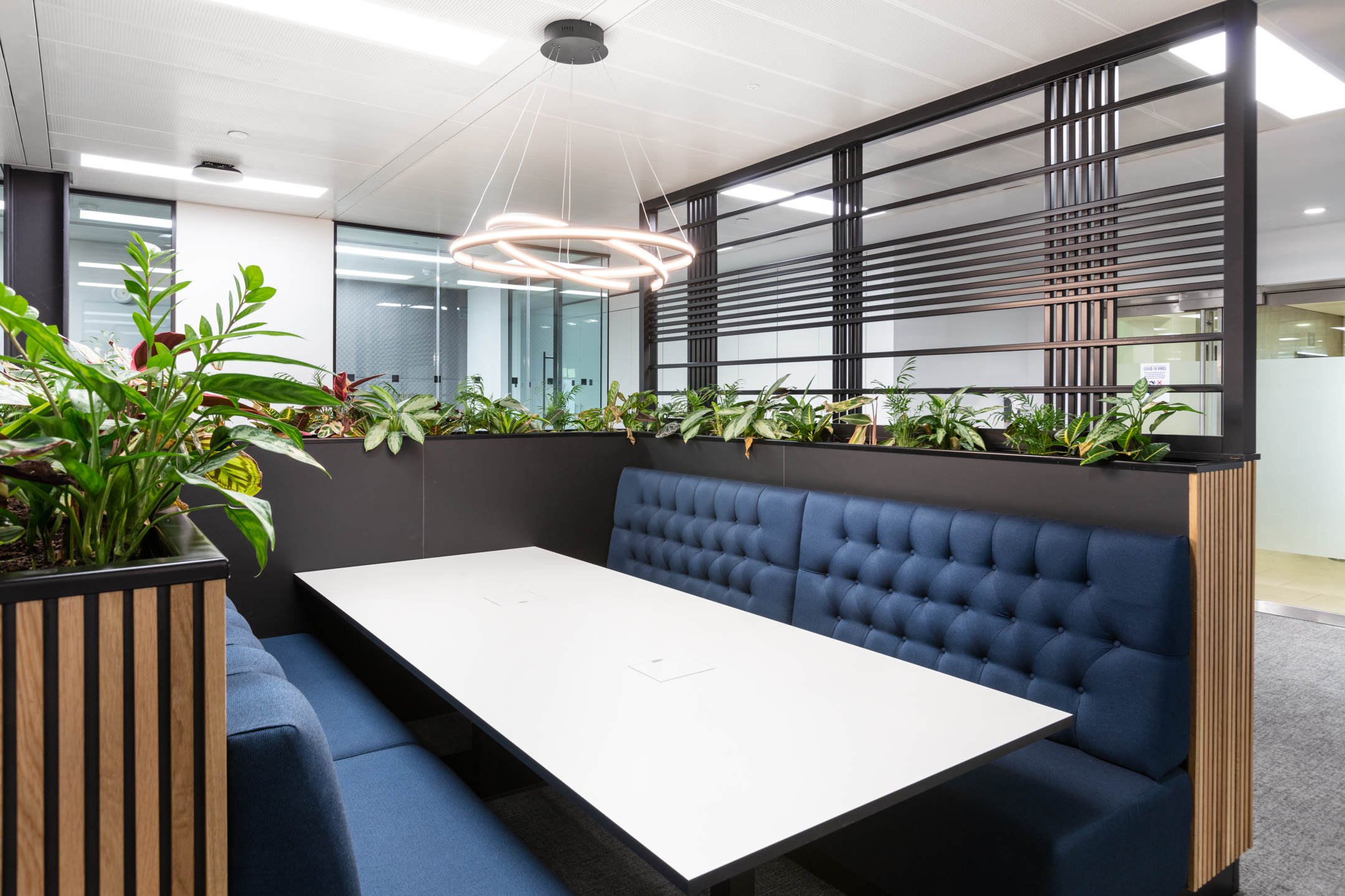 Russell Reynolds Associates meeting booth with high-backed blue seating, layered planting and furniture by Platfform built for privacy and ease.