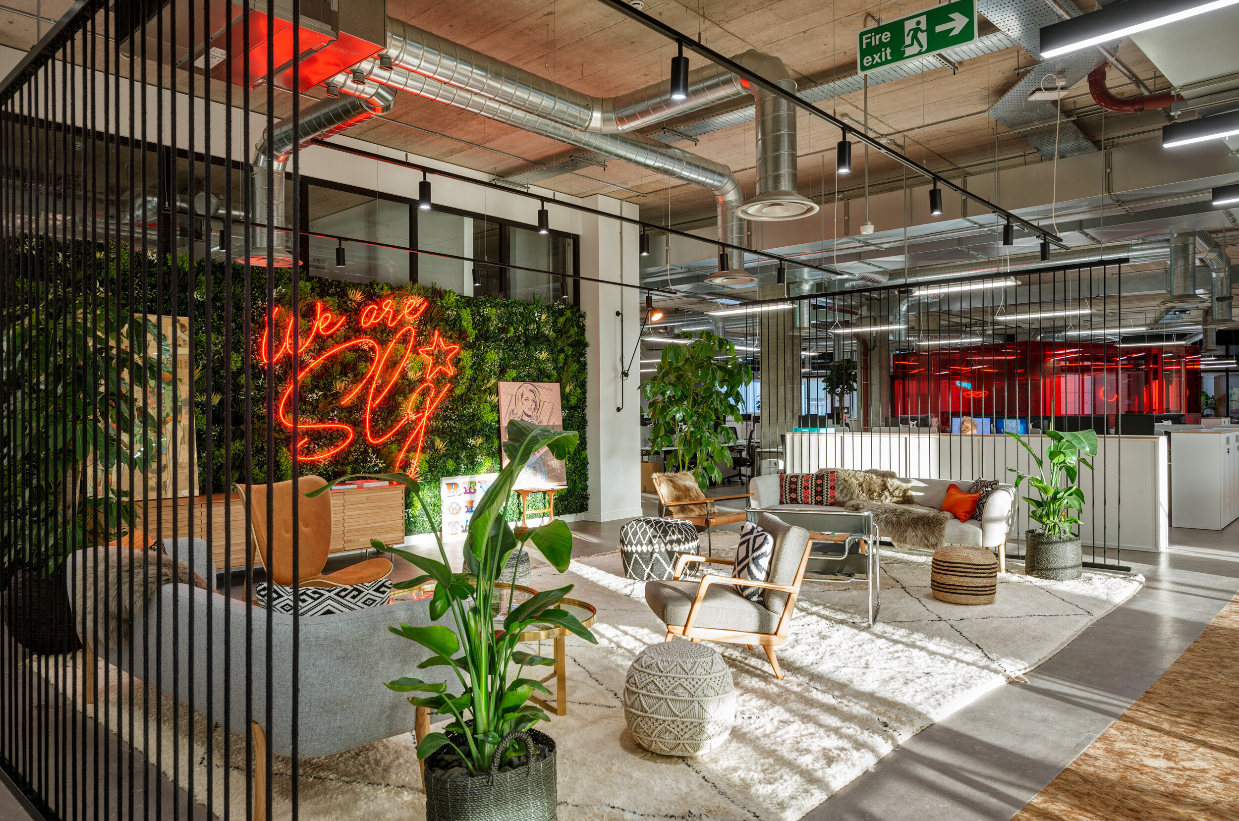SLG breakout zone in Cheltenham furnished with soft seating, pouffes and timber details, layered with bold colours and textures for brand impact.