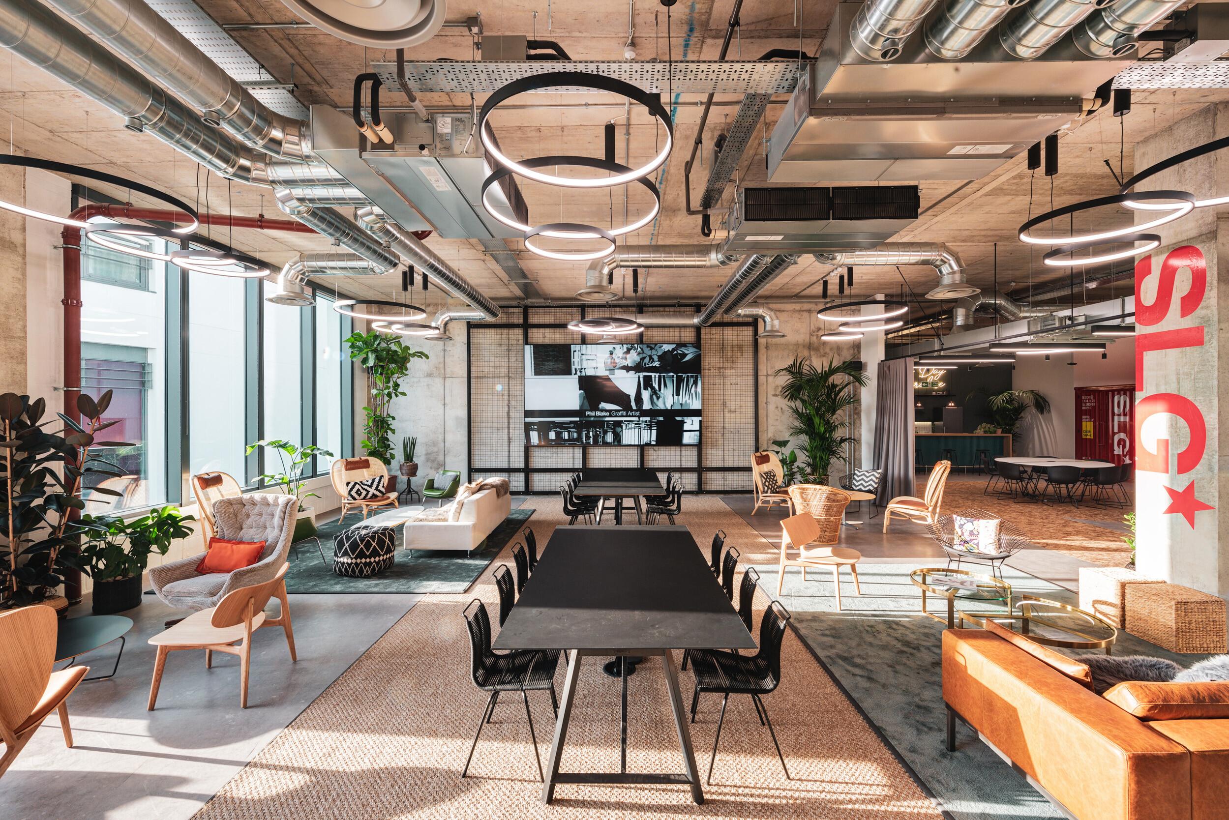SLG HQ in Cheltenham with a flexible events and breakout space, furnished with dining tables, lounge seating and soft textures throughout.