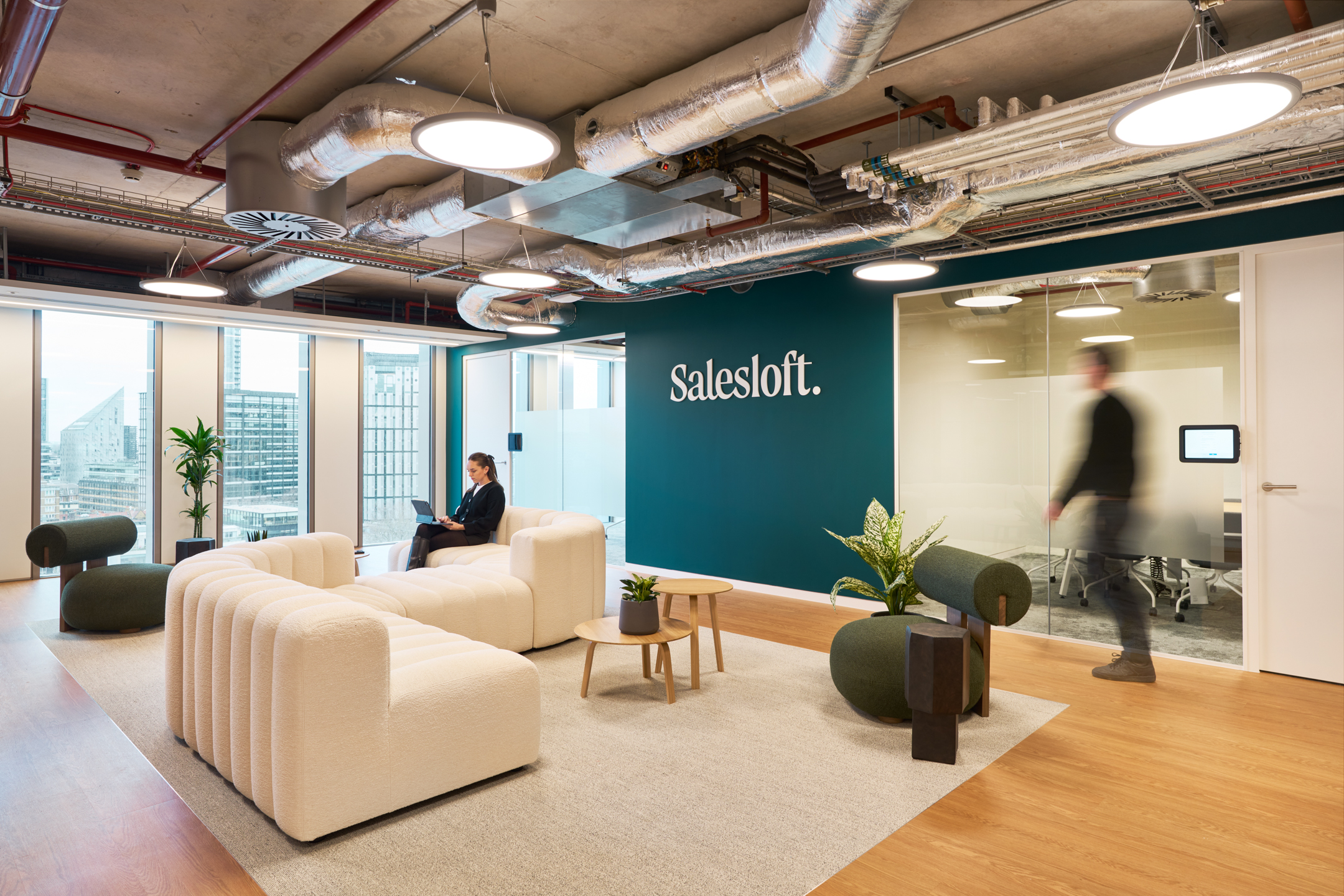 Salesloft reception with boucle seating and bold green lounge chairs, furnished by Platfform to align with the brand’s hospitality-driven workplace design.