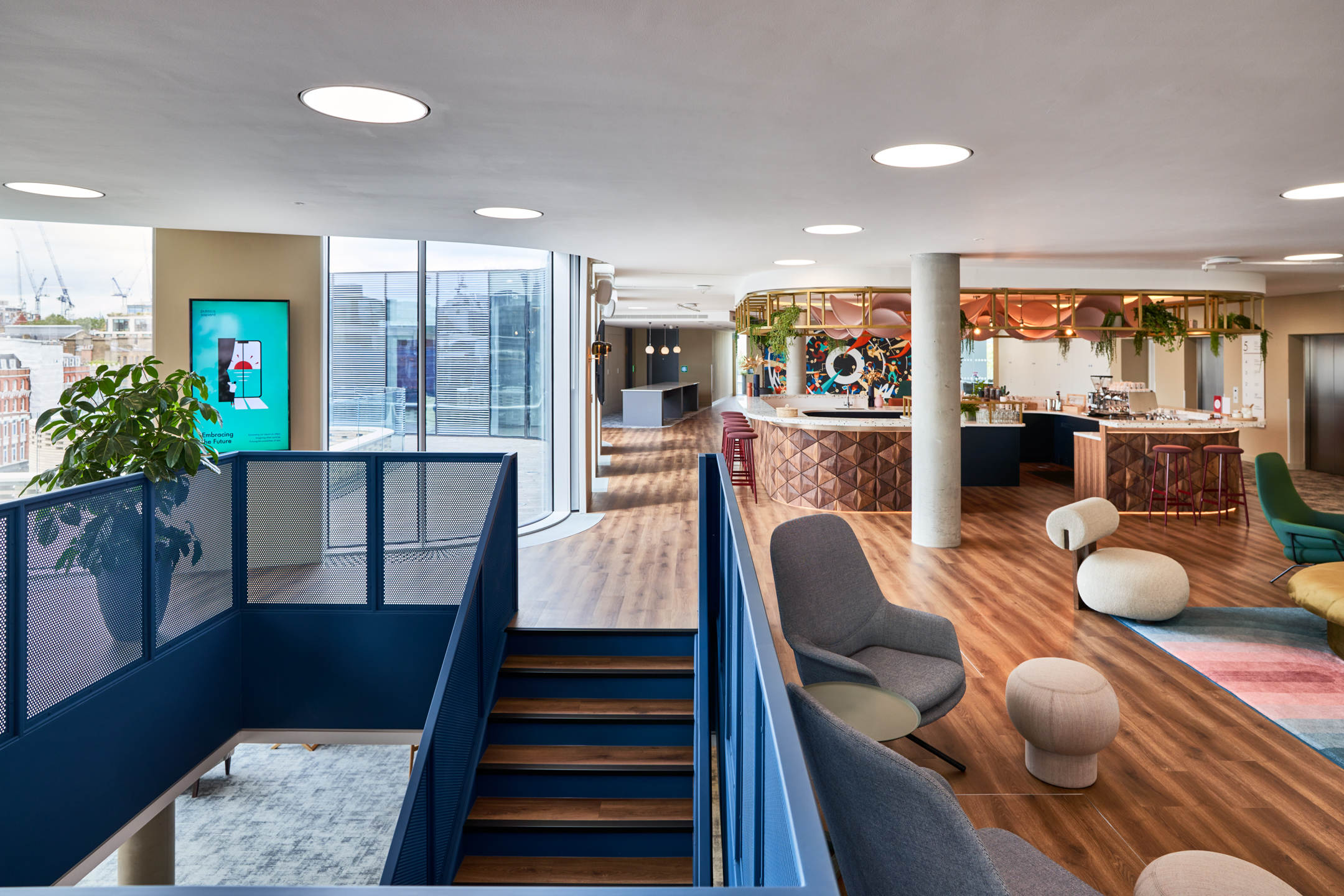 Upper floor at Publicis Sapient with Platfform furniture including sculptural seating and lounge chairs, leading to a statement teapoint bar and vibrant mural backdrop.