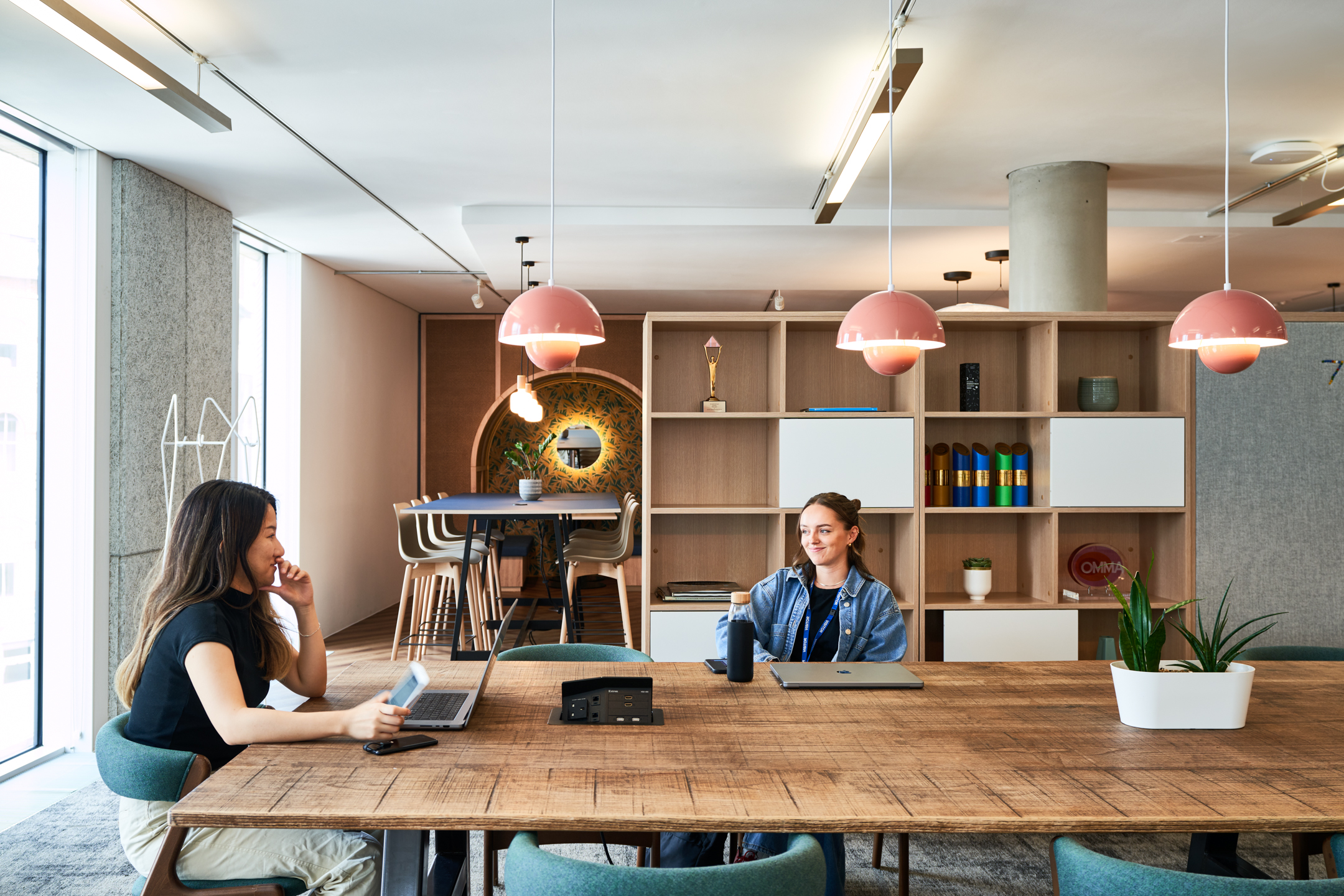 Collaborative workspace at Publicis Sapient furnished by Platfform, with natural wood tables, pastel pendant lighting, and a mix of seating options for focused or informal work.