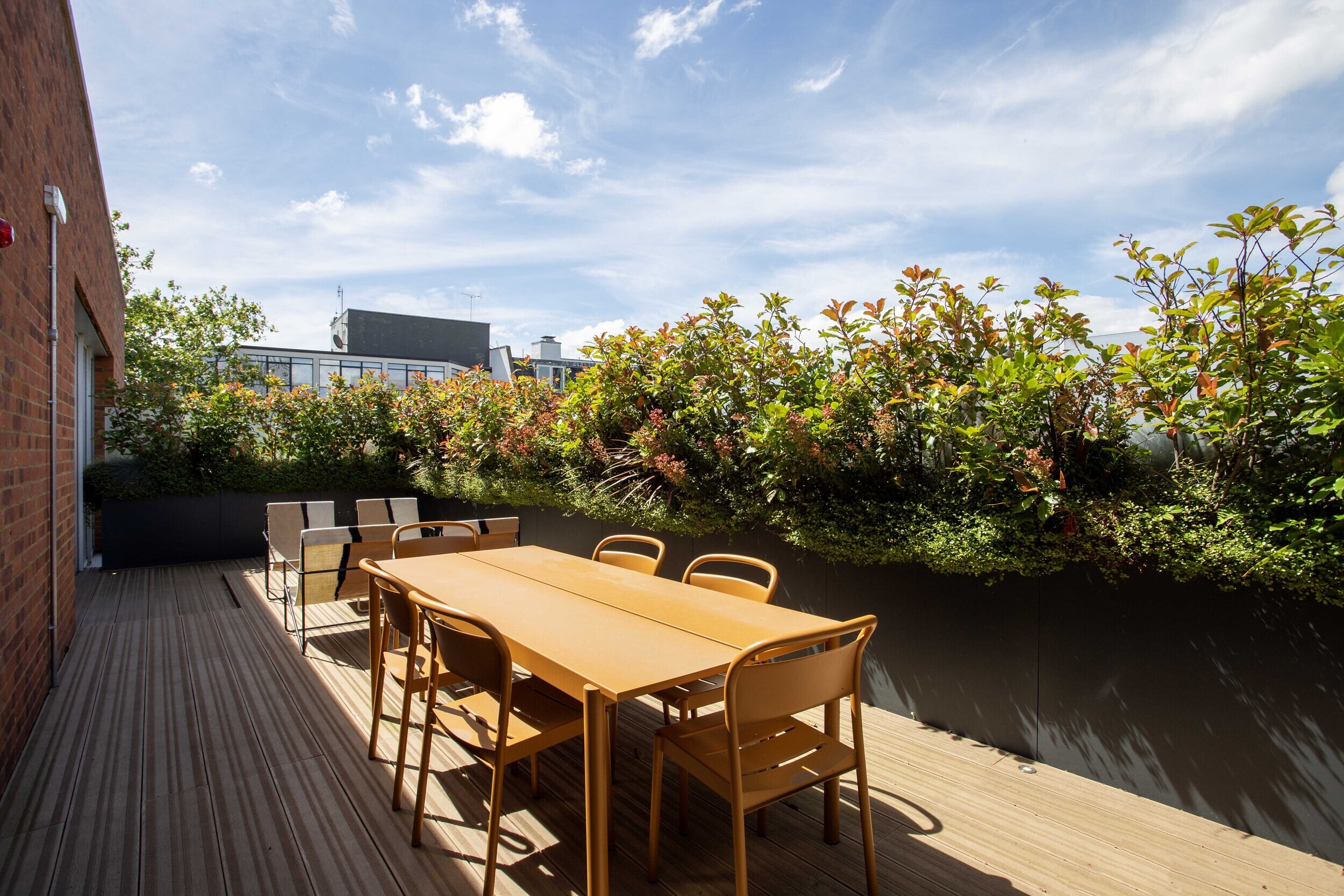 Techspace terrace with orange dining table and chairs styled for open air meetings and team lunches