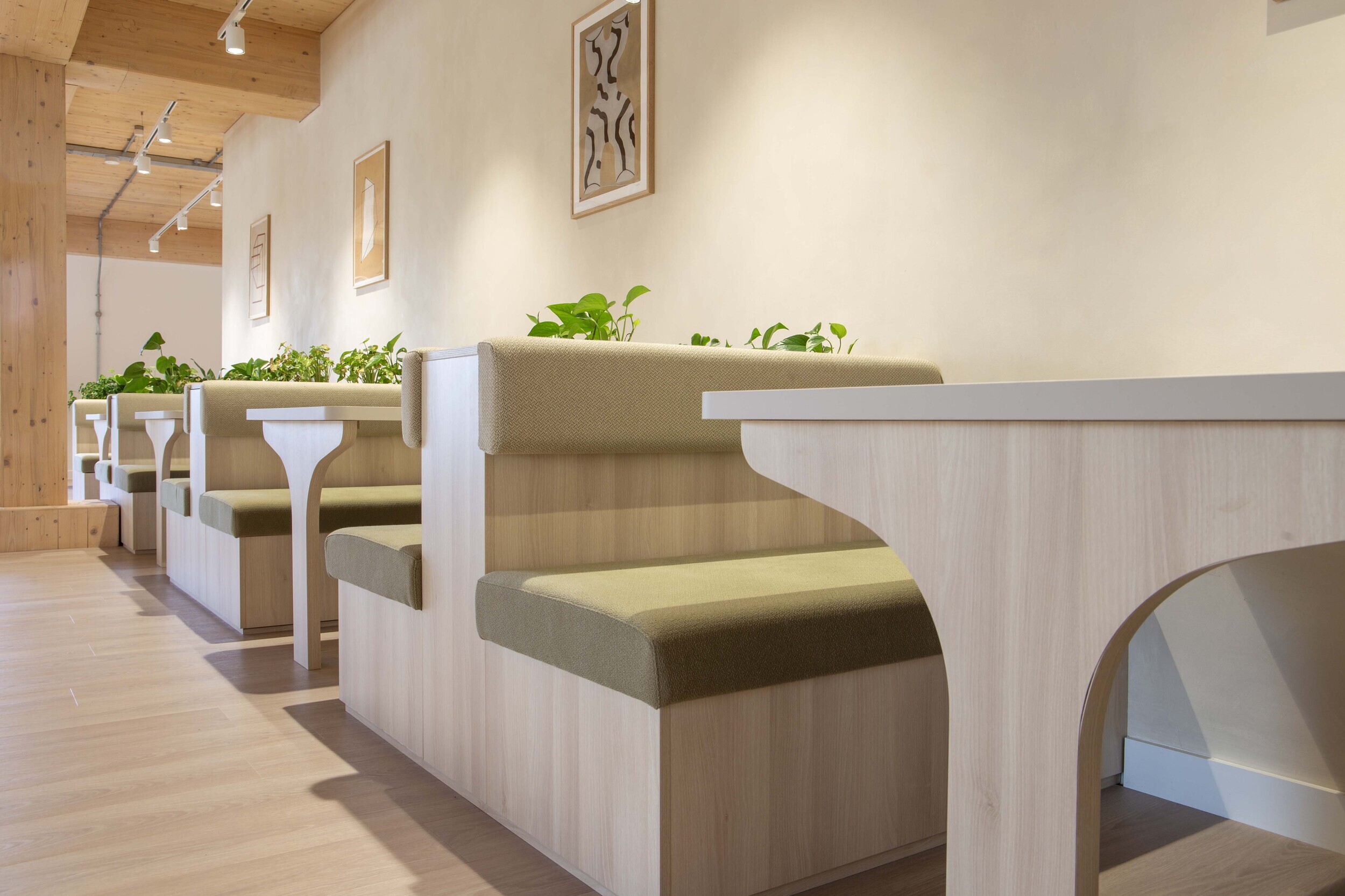 Techspace breakout area with booth seating and integrated planting designed for quiet collaboration and focused work