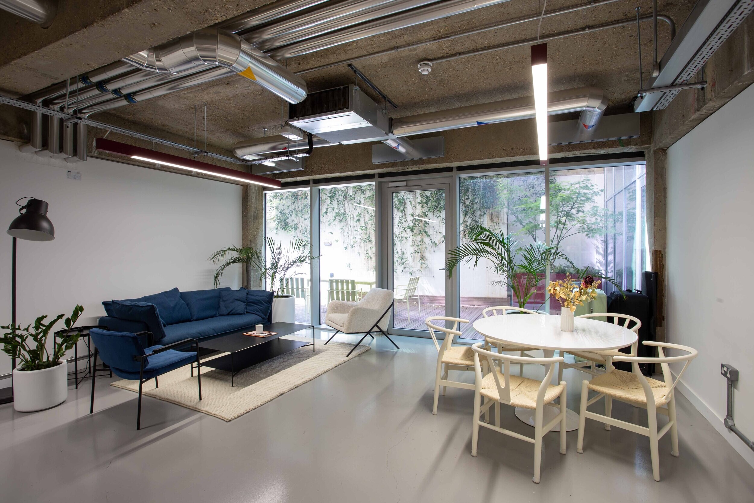 Techspace breakout space with blue sofa round dining table and lounge seating styled for informal work and downtime