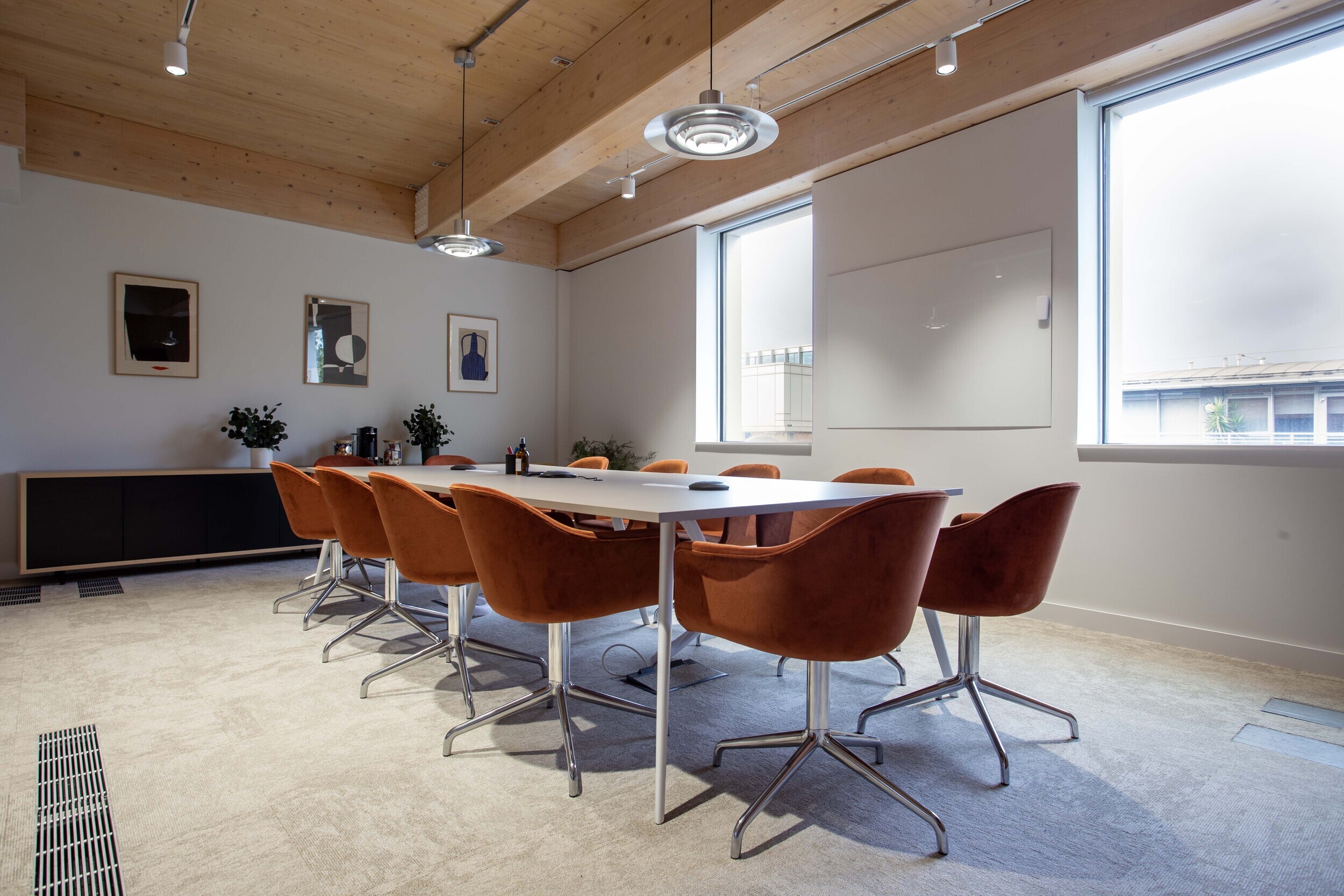 Techspace meeting room with orange swivel chairs and long white table designed for team collaboration and client sessions