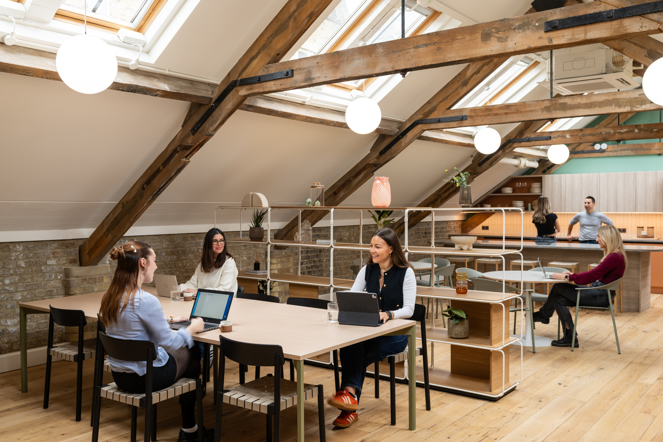 Mixed seating and modular shelving bring softness to the top-floor workspace at The Varnish Works, layered with texture and historic character