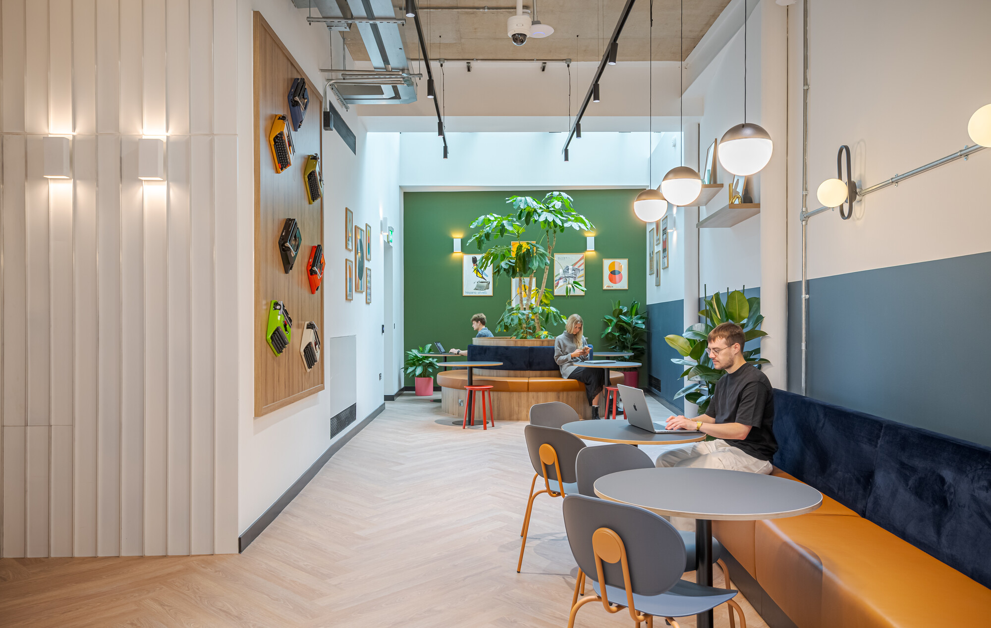 Work.Life Typewriter breakout space with layered seating, statement greenery and vintage typewriters celebrating the building’s creative story.