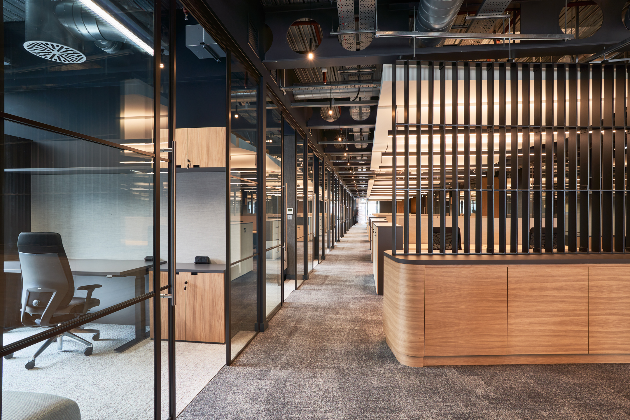 Glazed private offices and textured wooden joinery shape the central workspace at United Talent Agency, finished with refined furniture from Platfform.
