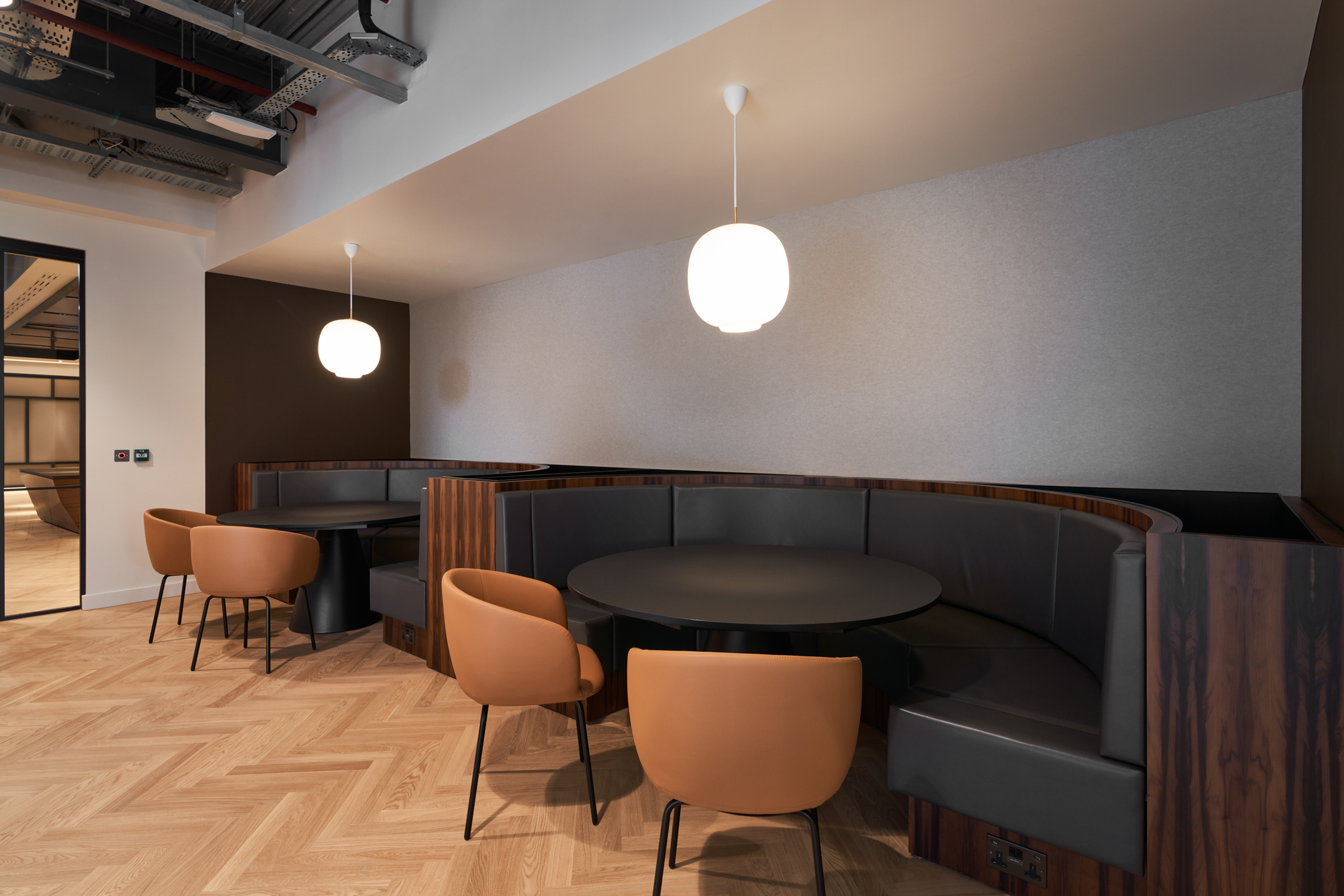 Café-style seating at United Talent Agency, with leather tub chairs and curved banquettes installed by Platfform for relaxed, informal collaboration.