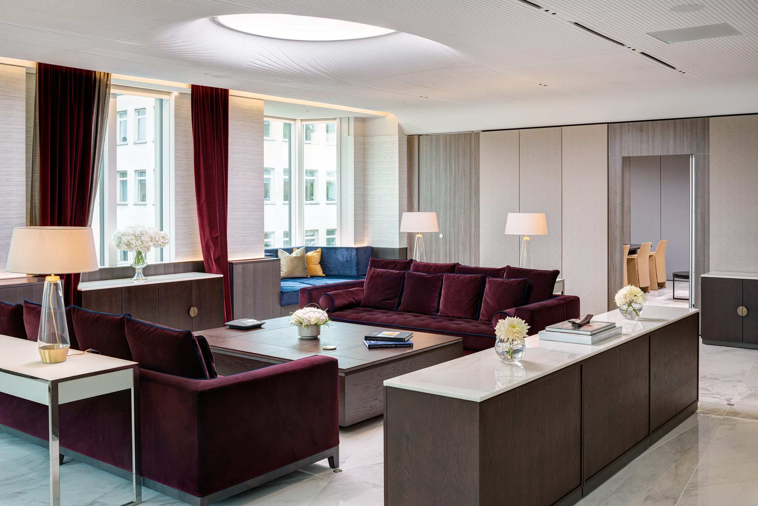 Lounge furniture for Vedanta’s London office, including deep burgundy sofas and marble-topped tables, creating a luxurious client-facing space.