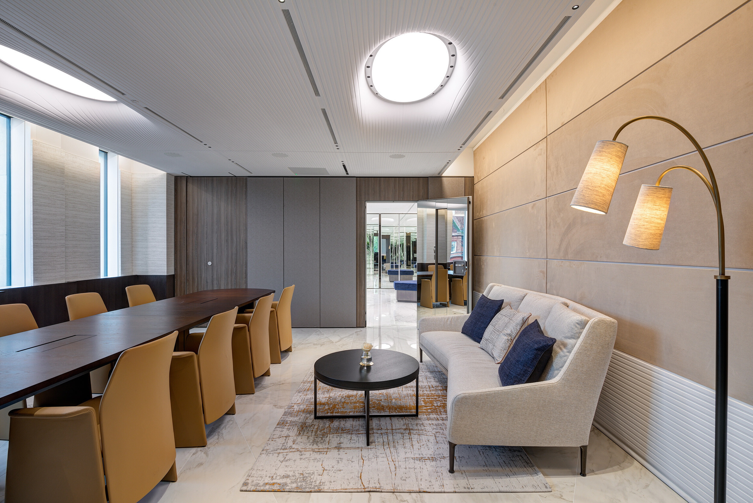 Multi-purpose meeting space at Vedanta’s office with neutral-toned lounge furniture and a long conference table designed for comfort and flexibility.
