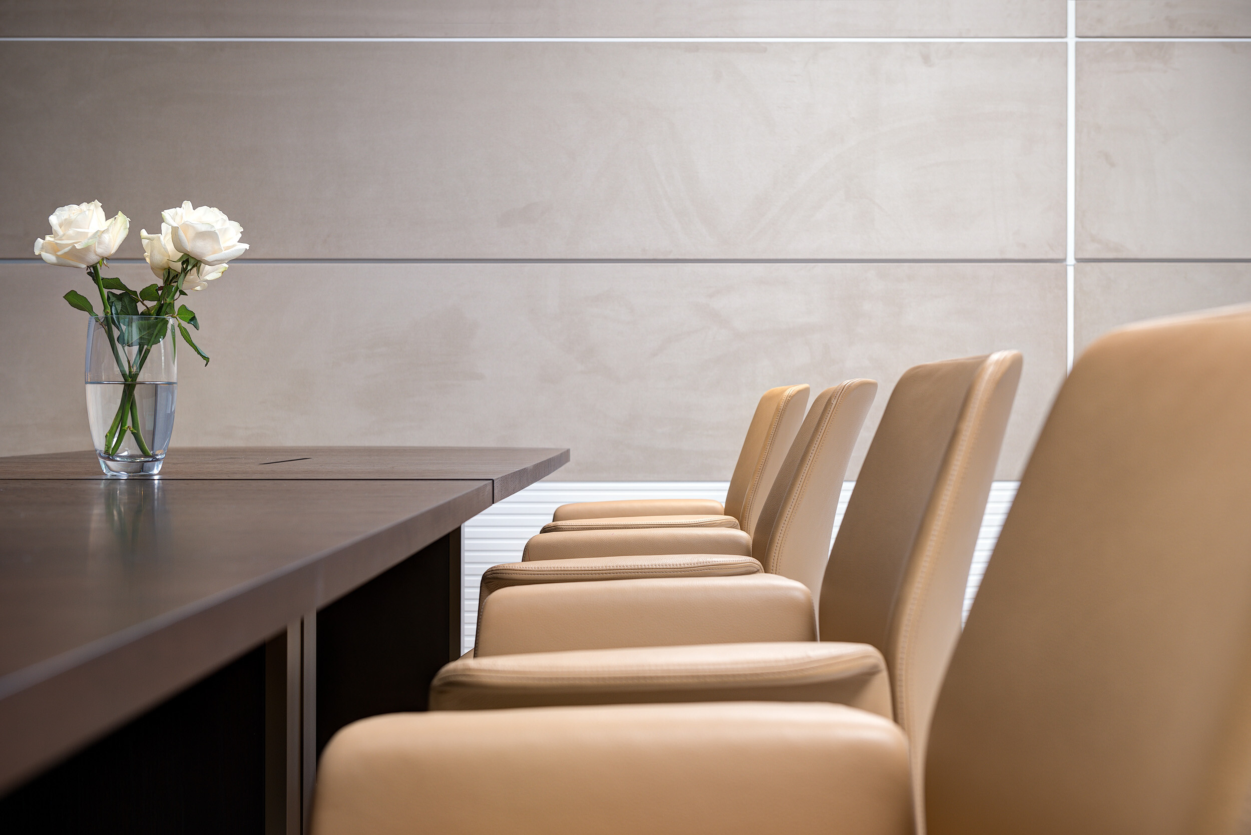 Detail of tan leather meeting chairs at Vedanta’s London office, paired with a dark wood table and minimalist styling for a refined finish.