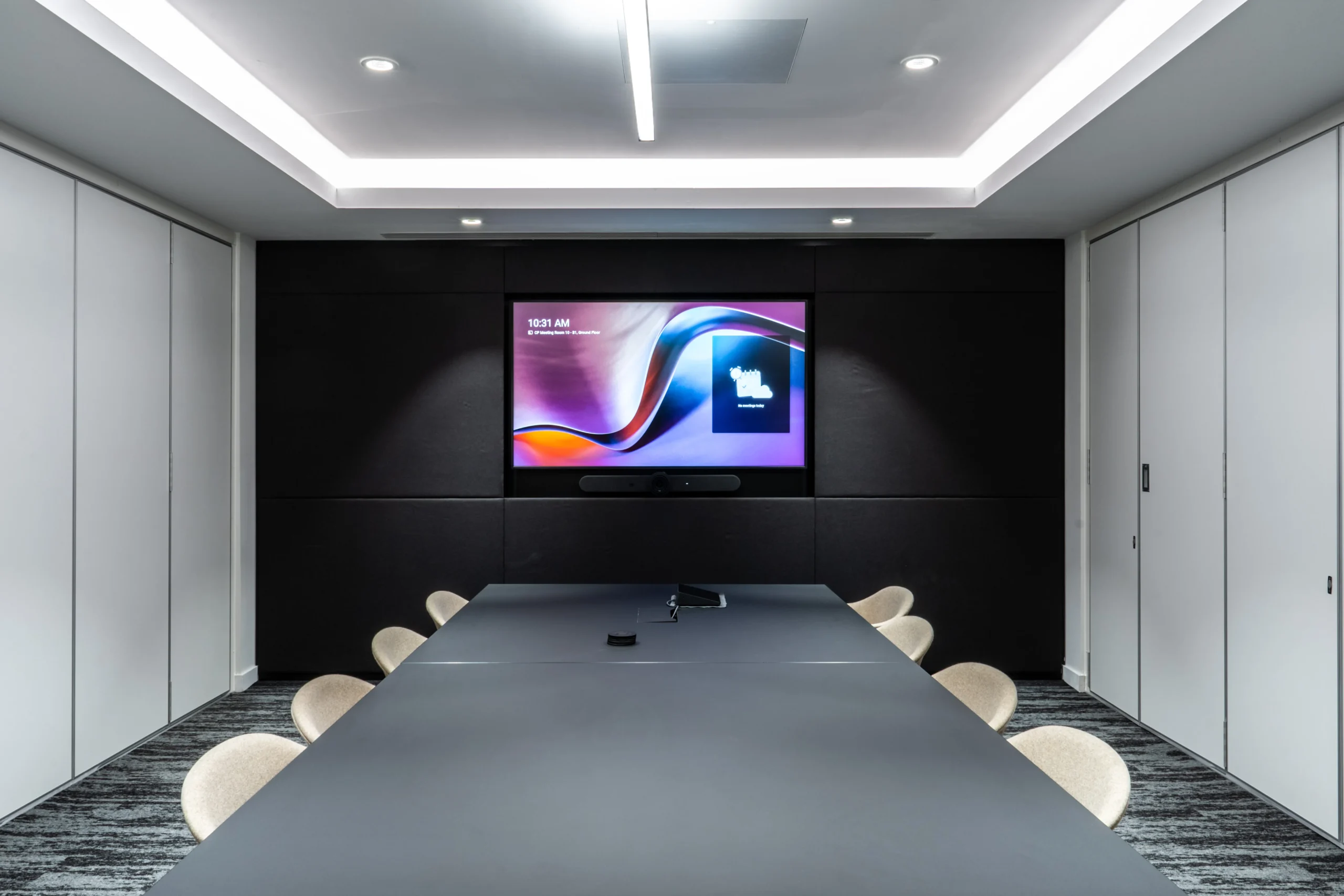 Boardroom at Watches of Switzerland with a sleek matte table, neutral seating, and built-in screen for high-spec meetings and presentations