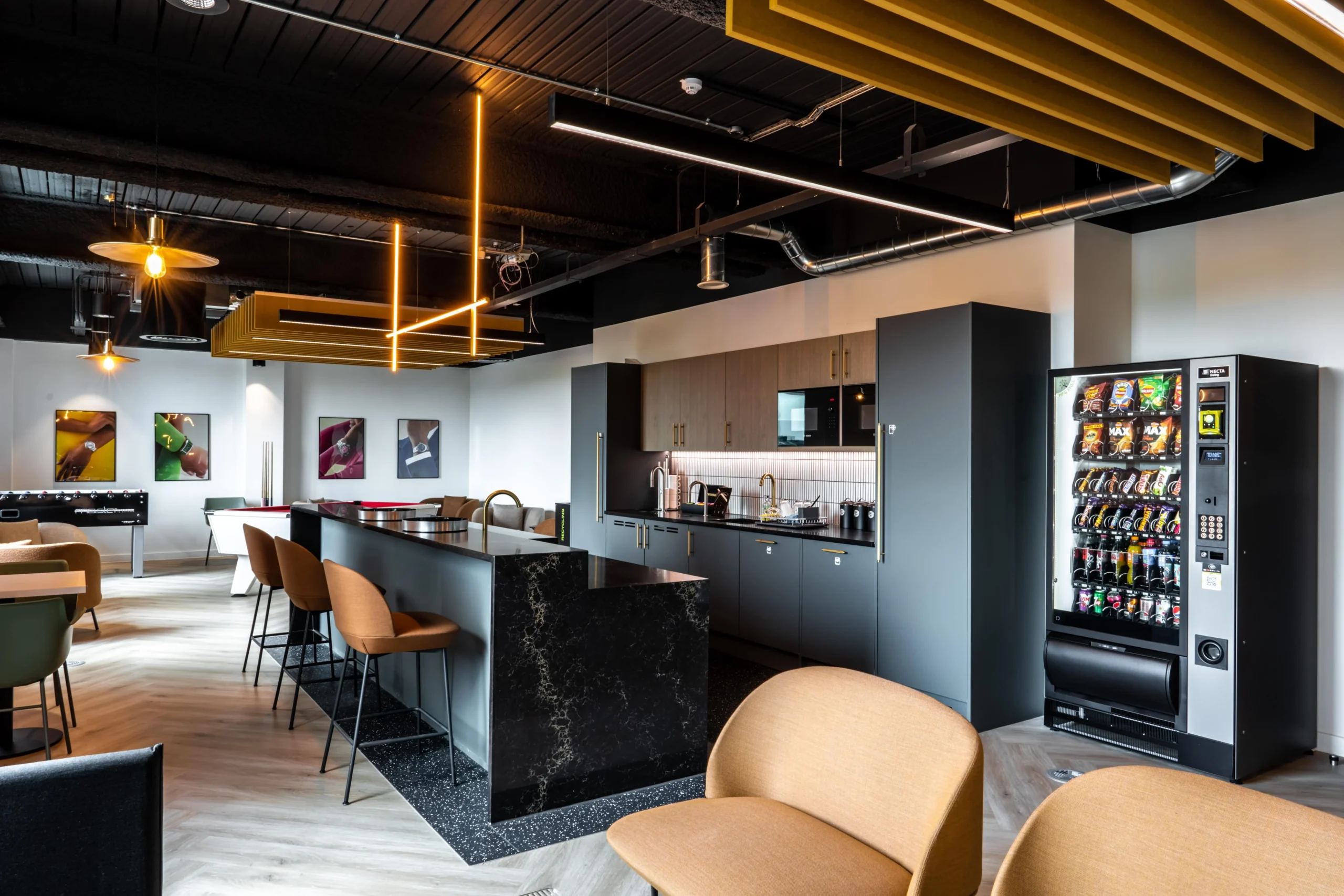 Teapoint at Watches of Switzerland with a black marble island, vending machines, soft seating and bold lighting details