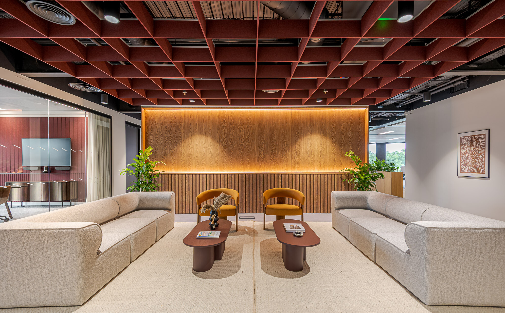 Tenant-Ready™ reception space at Arbor furnished by Platfform, showcasing twin curved sofas, amber armchairs and matching coffee tables beneath a statement red grid ceiling.