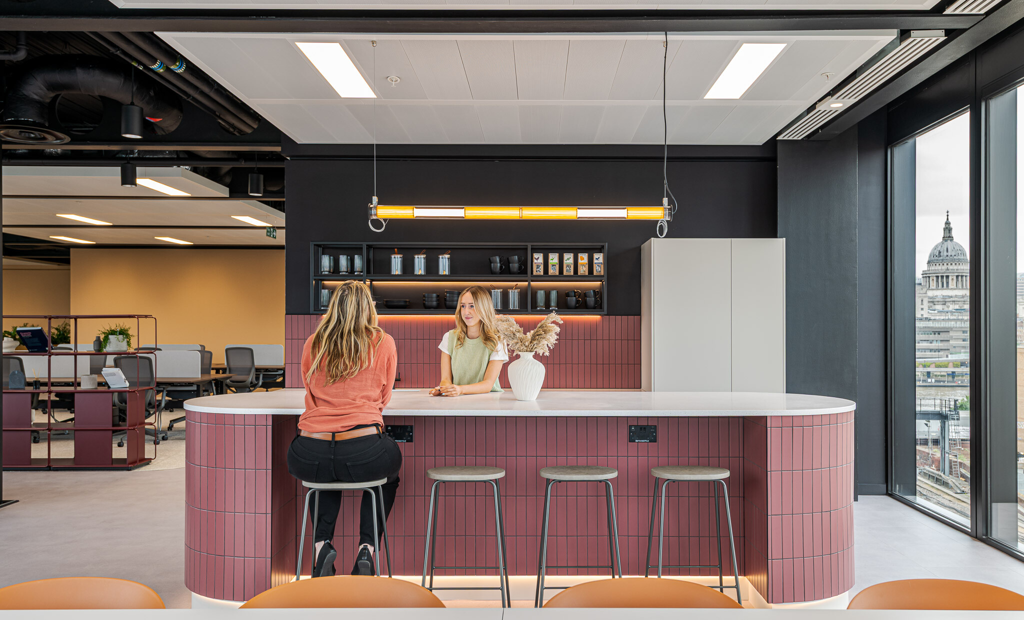 Collaborative teapoint in Arbor’s Tenant-Ready™ workspace, furnished by Platfform, with a curved tiled island and bar stools, set against a backdrop of St Paul’s Cathedral.