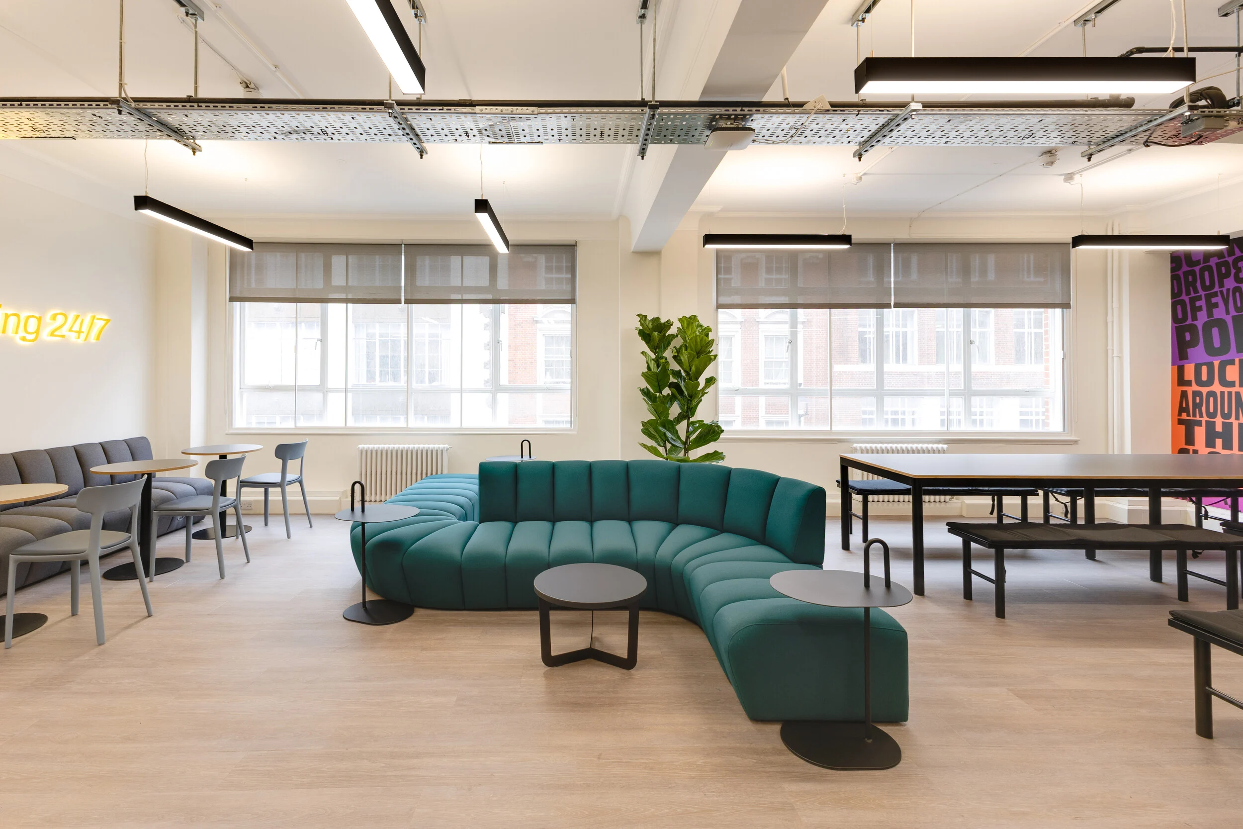 InPost’s social space furnished by Platfform, with a bespoke snake sofa from JDD’s Terry range in teal. The curved seating anchors the room alongside flexible tables and benches.