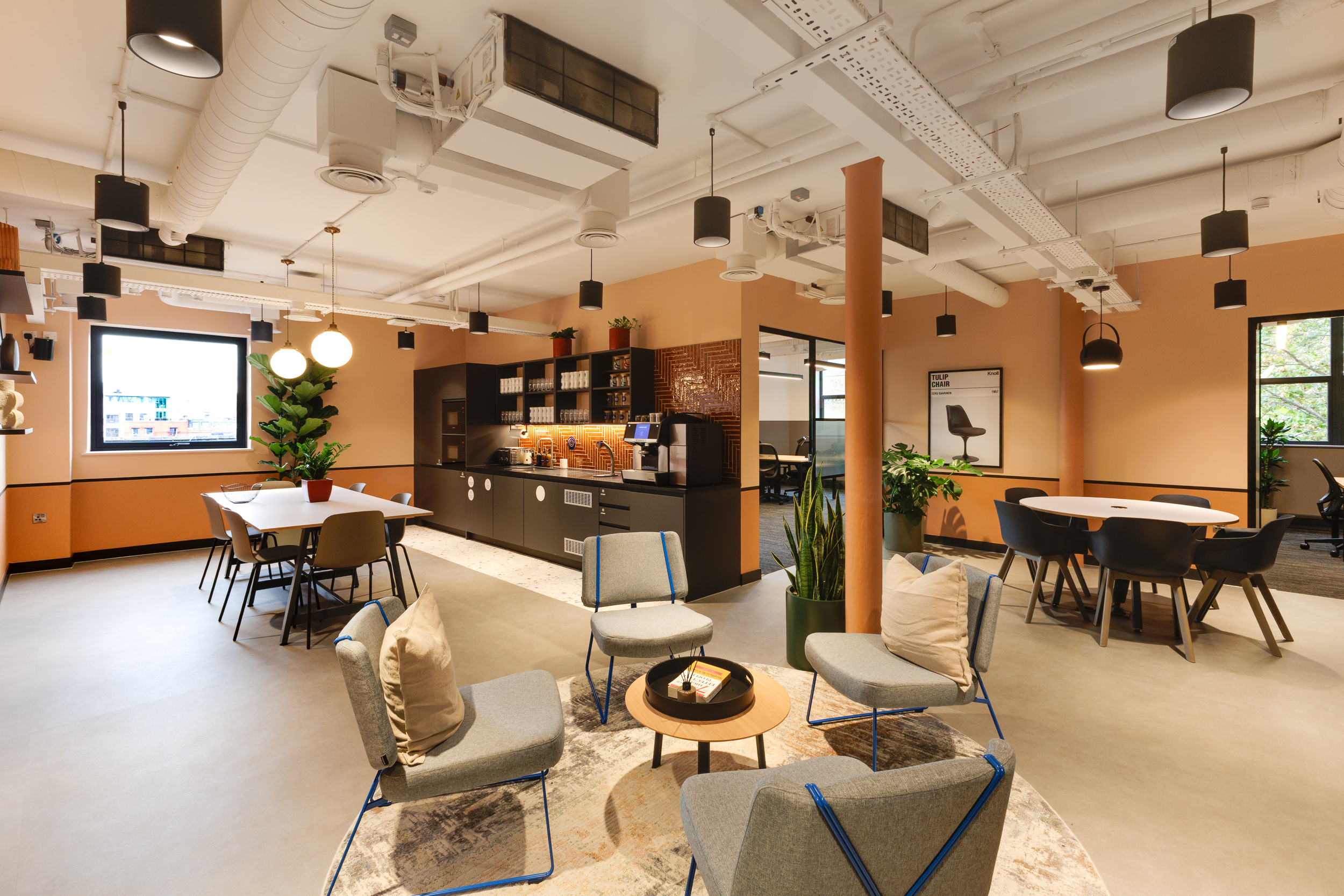 Level 4 teapoint at Work.Life Clerkenwell Green with coral walls, grey seating and open lounge area, furnished by Platfform.
