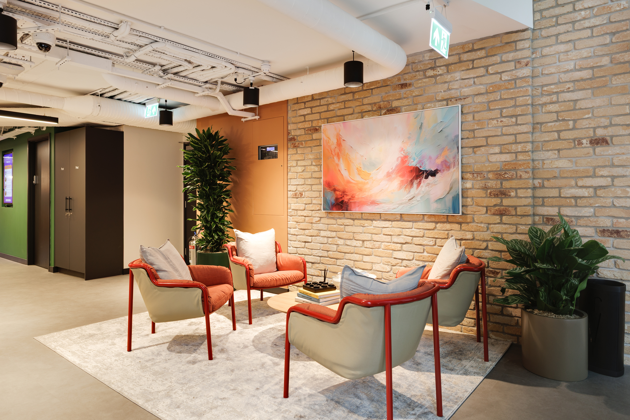 Lounge area beside the teapoint and reception at Work.Life Clerkenwell Green, featuring warm tones, textured brick walls and modern furniture supplied by Platfform.
